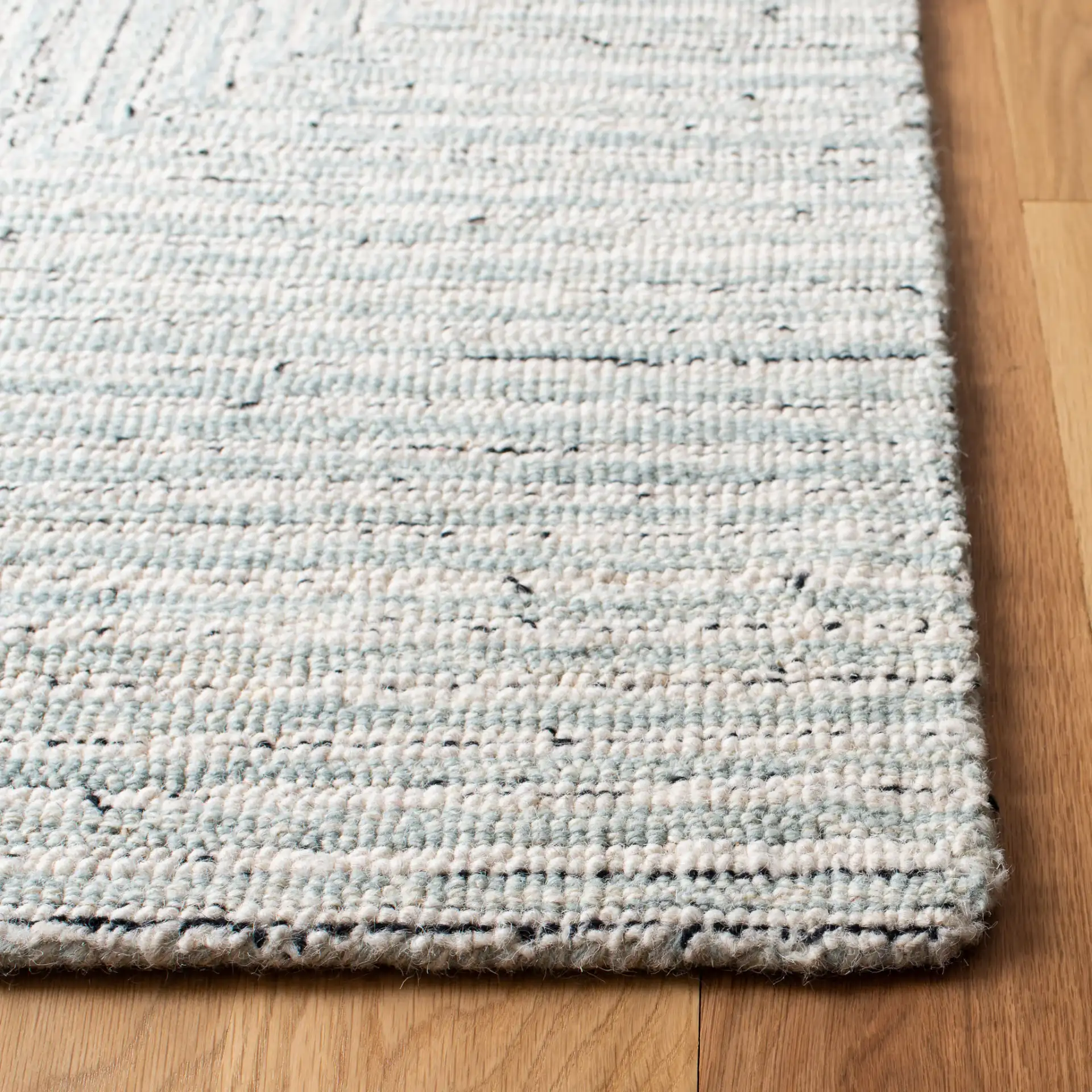 Micro-Loop Concentric Maze Hand-Tufted Wool Rug in Light Gray / Ivory in a styled room