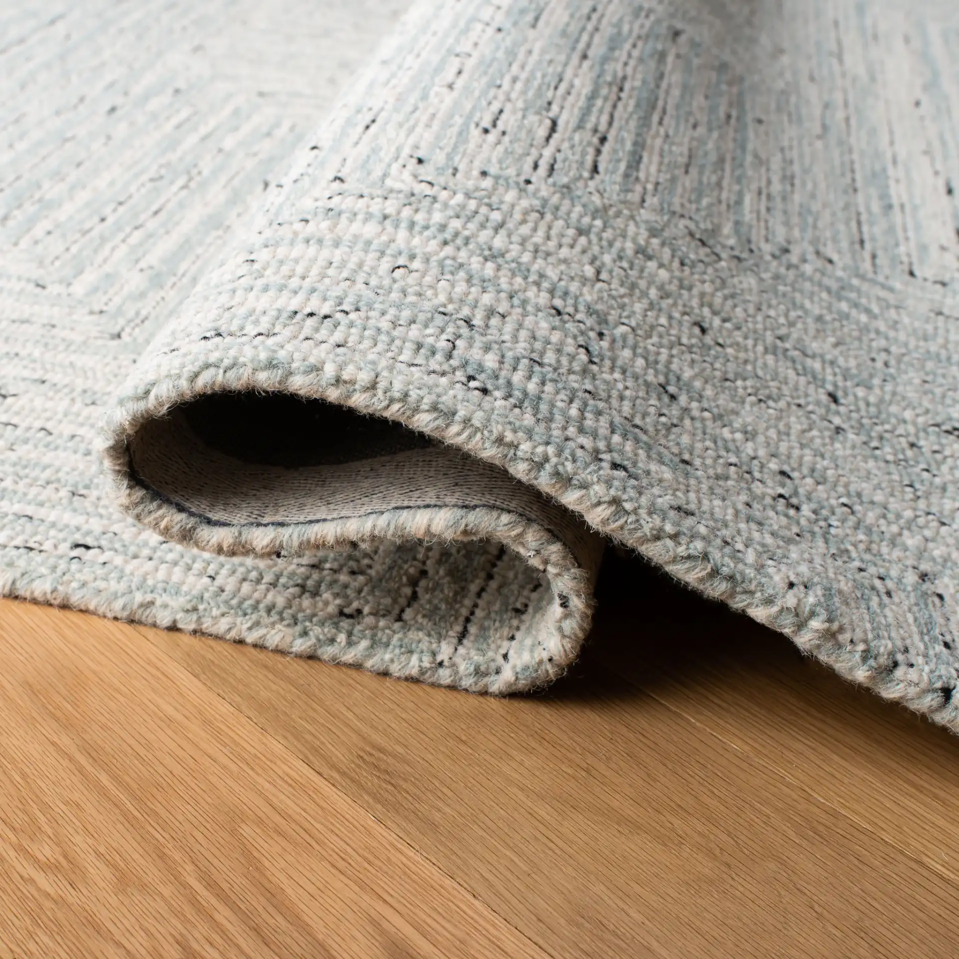 Micro-Loop Concentric Maze Hand-Tufted Wool Rug in Light Gray / Ivory in a styled room