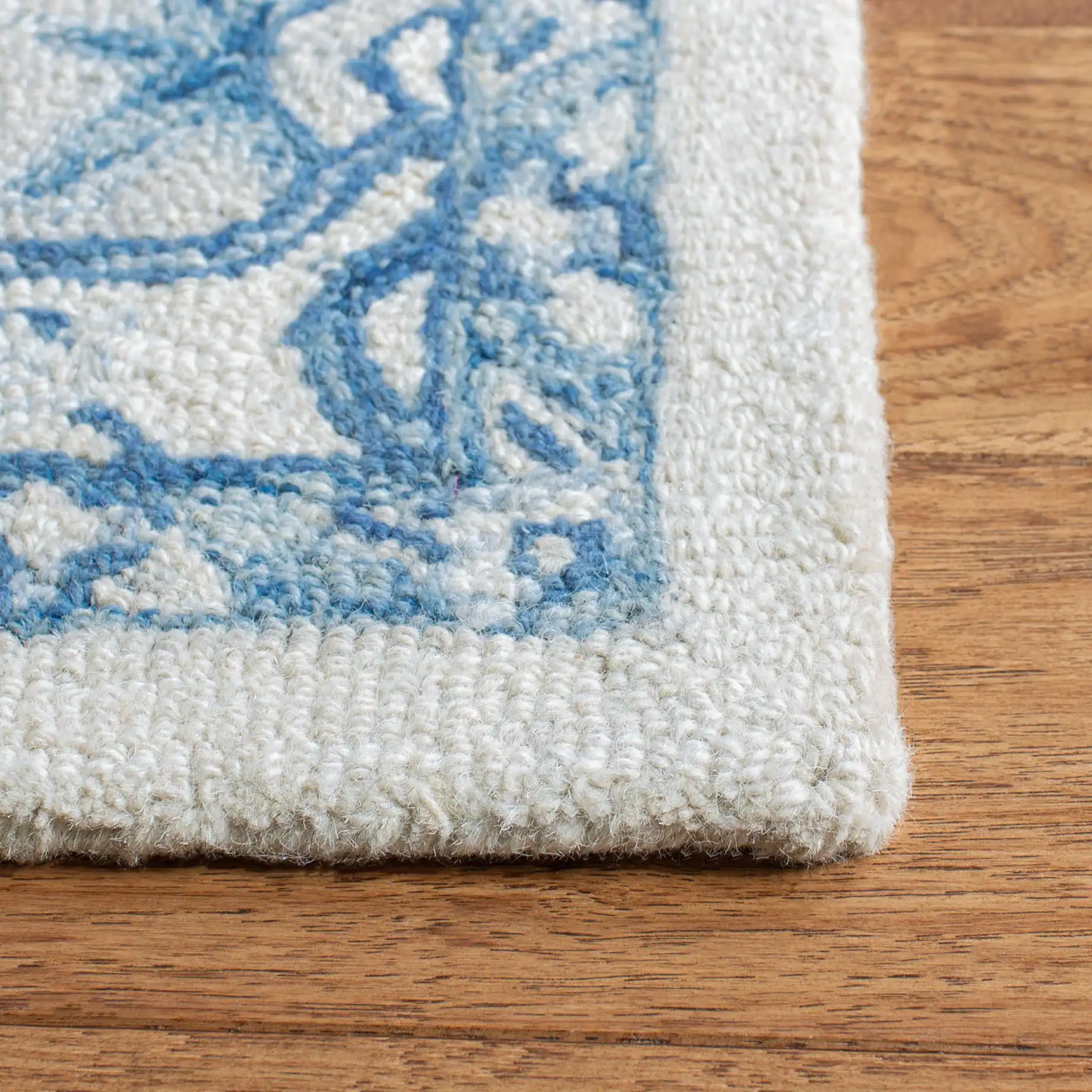 Micro-Loop Micro Loop Stepped Medallion Hand-Tufted Wool Rug in Ivory / Blue in a styled room