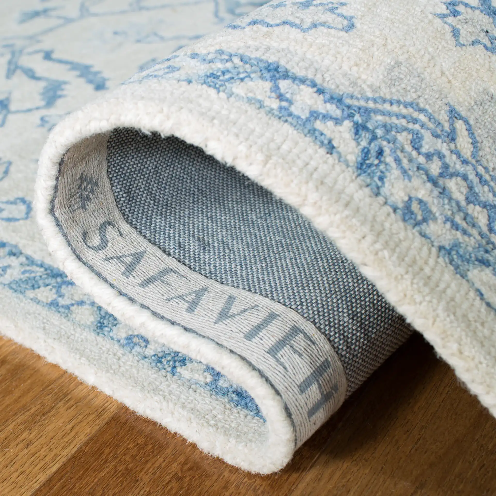 Micro-Loop Micro Loop Stepped Medallion Hand-Tufted Wool Rug in Ivory / Blue in a styled room