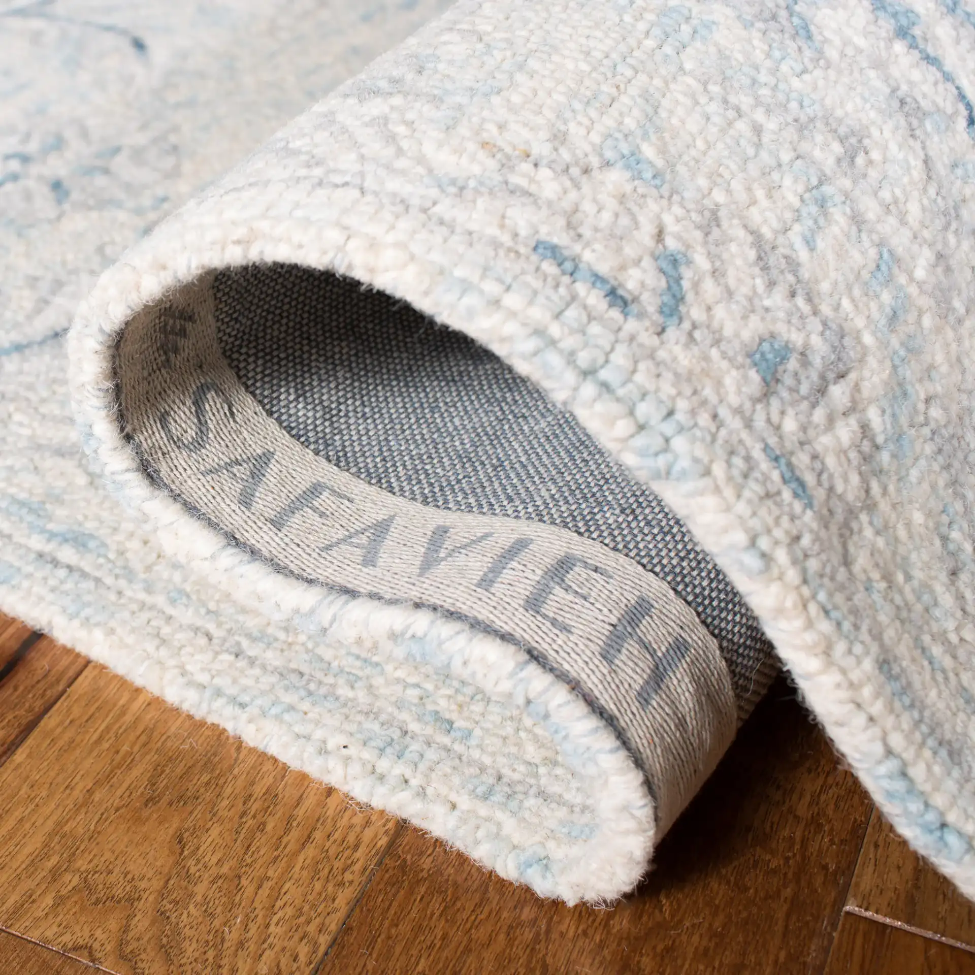 Micro-Loop Micro Loop Scrolling Floral Hand-Tufted Wool Rug in Light Blue / Ivory in a styled room