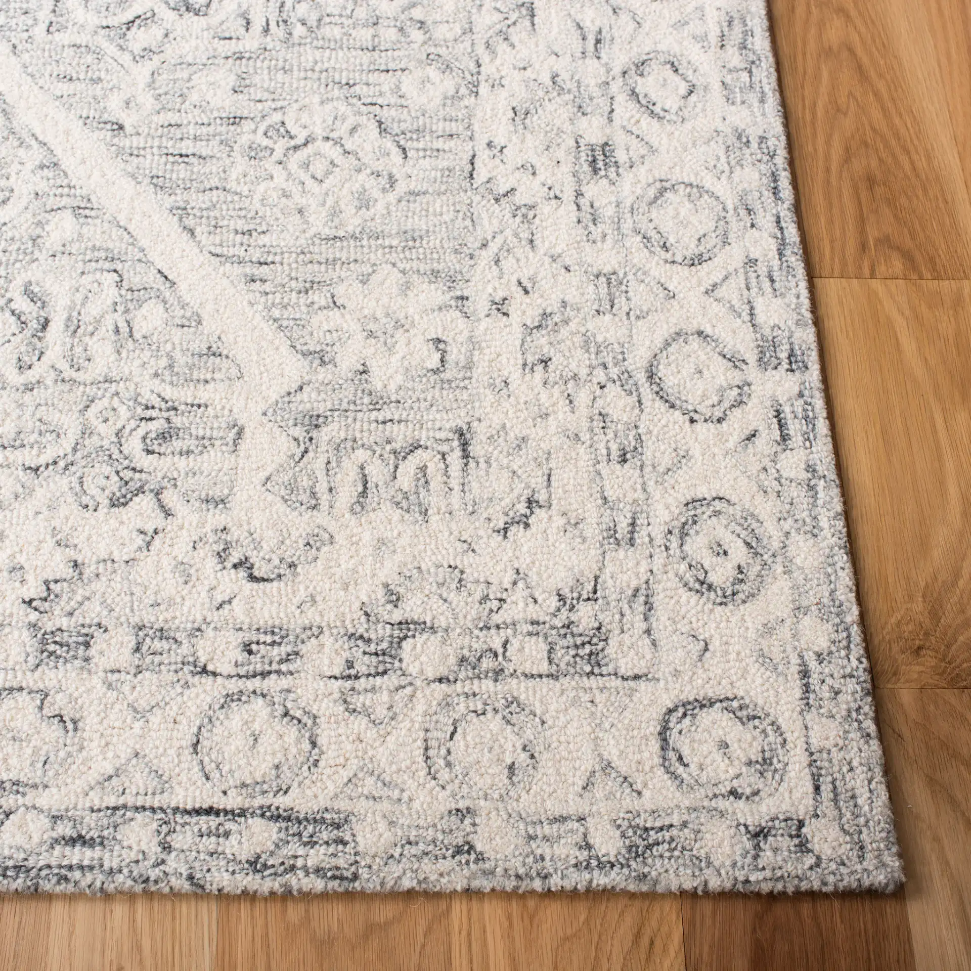 Micro-Loop Medallion Border Hand-Tufted Wool Rug in Charcoal / Ivory in a styled room