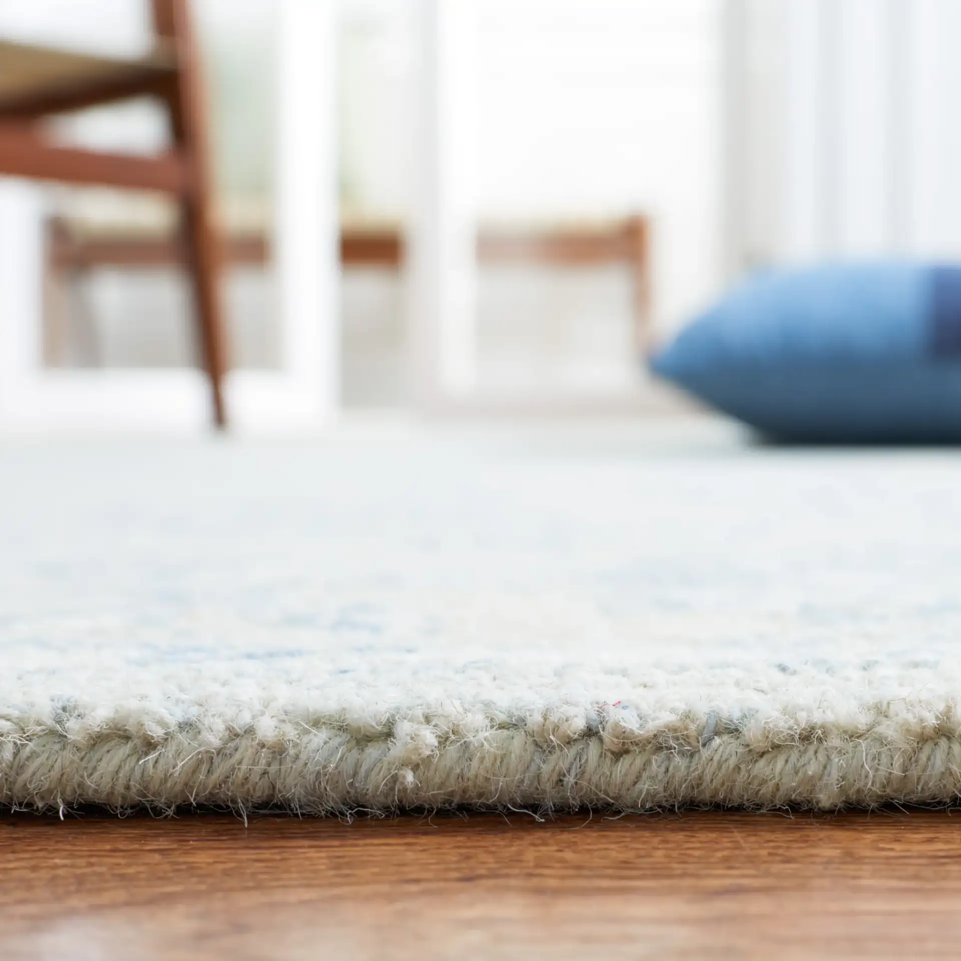 Micro-Loop Floral Border Hand-Tufted Wool Rug in Blue / Beige in a styled room