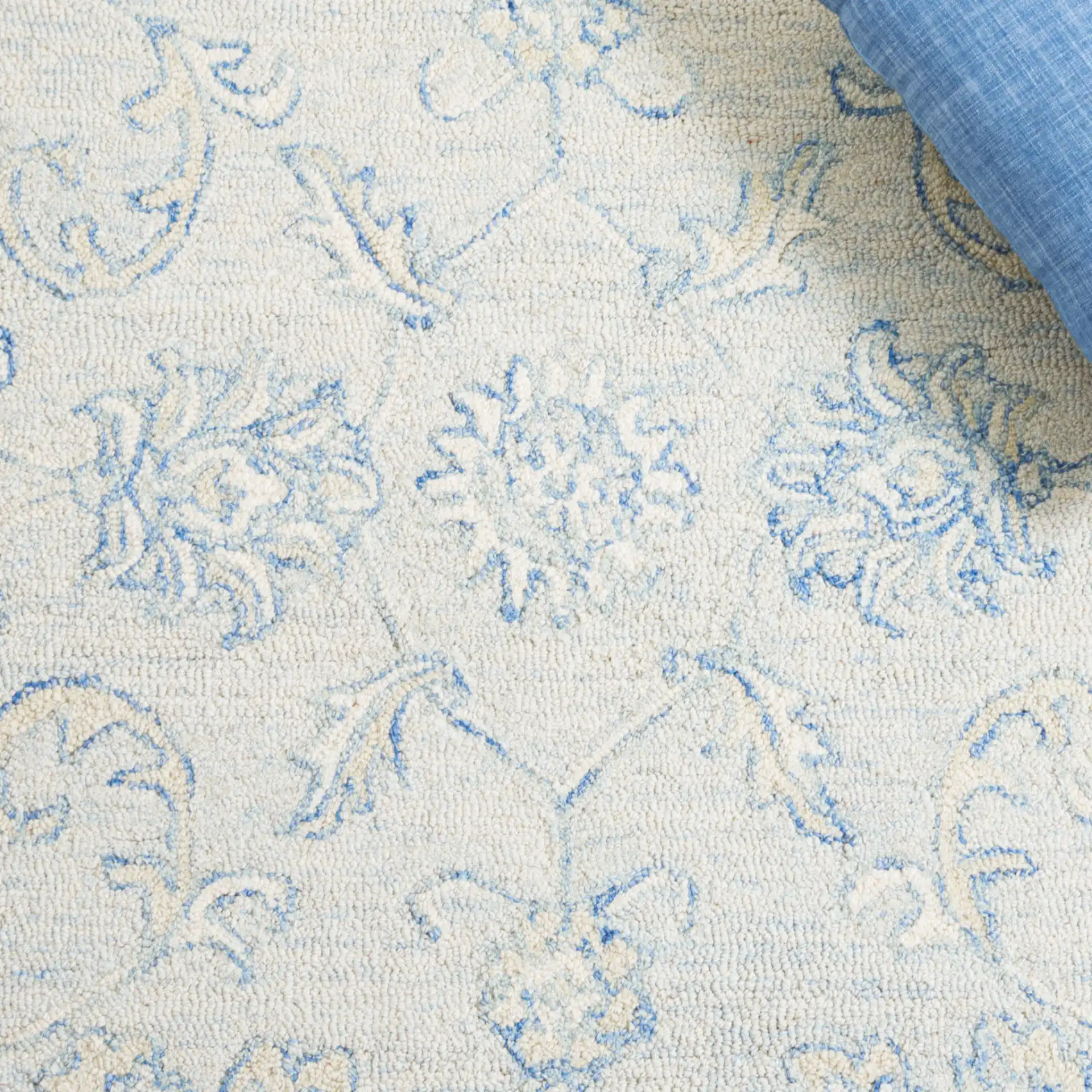 Micro-Loop Floral Border Hand-Tufted Wool Rug in Blue / Beige in a styled room