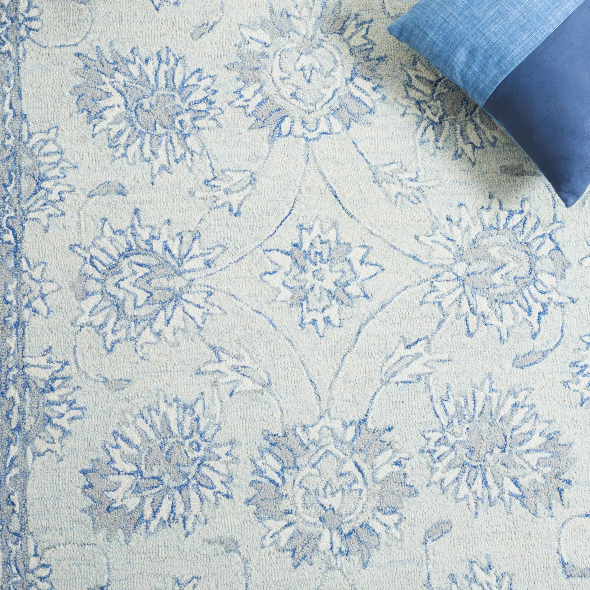 Micro-Loop Floral Border Hand-Tufted Wool Rug in Light Blue / Ivory in a styled room