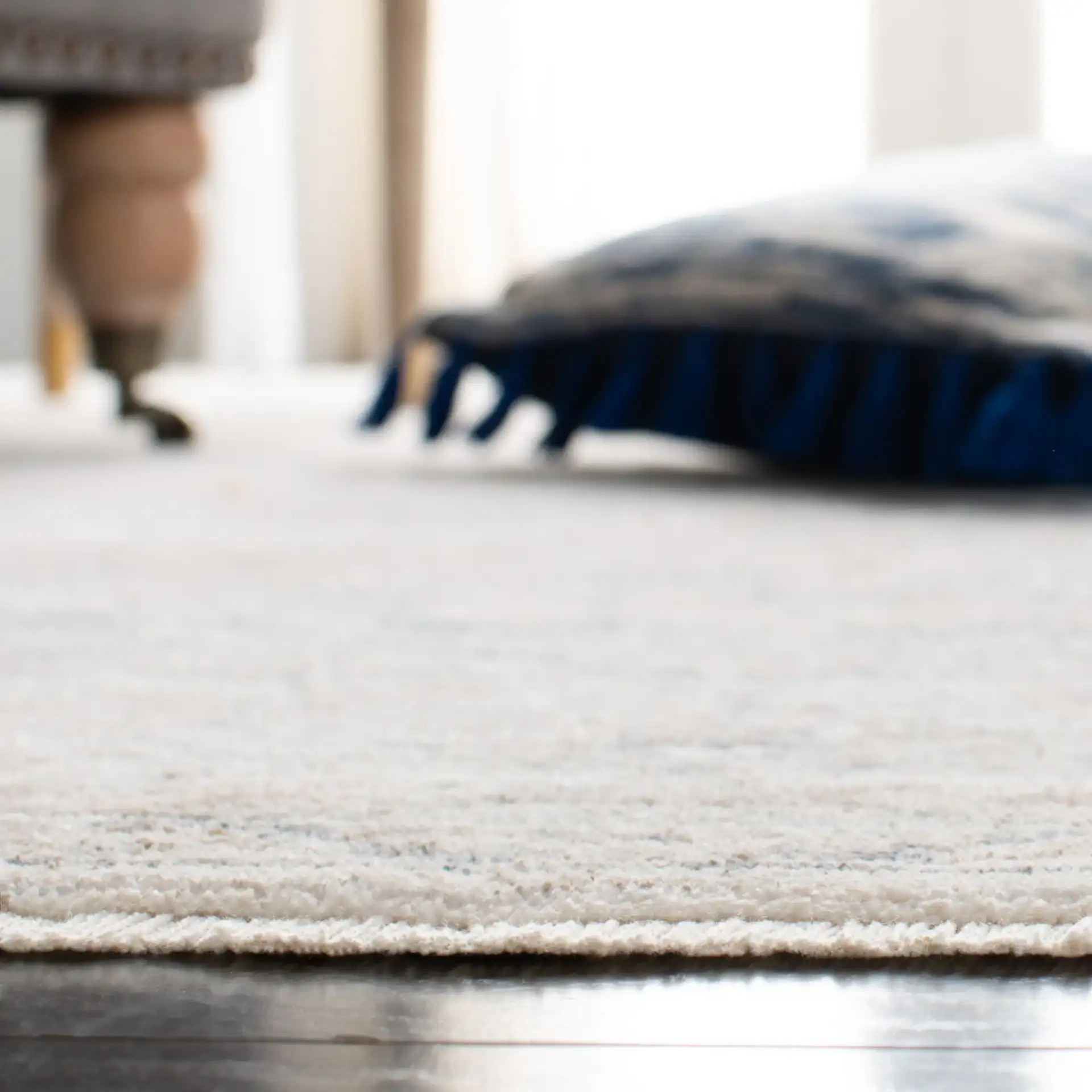 Moondust Faded Floral Bordered Rug in Beige / Gray in a styled room
