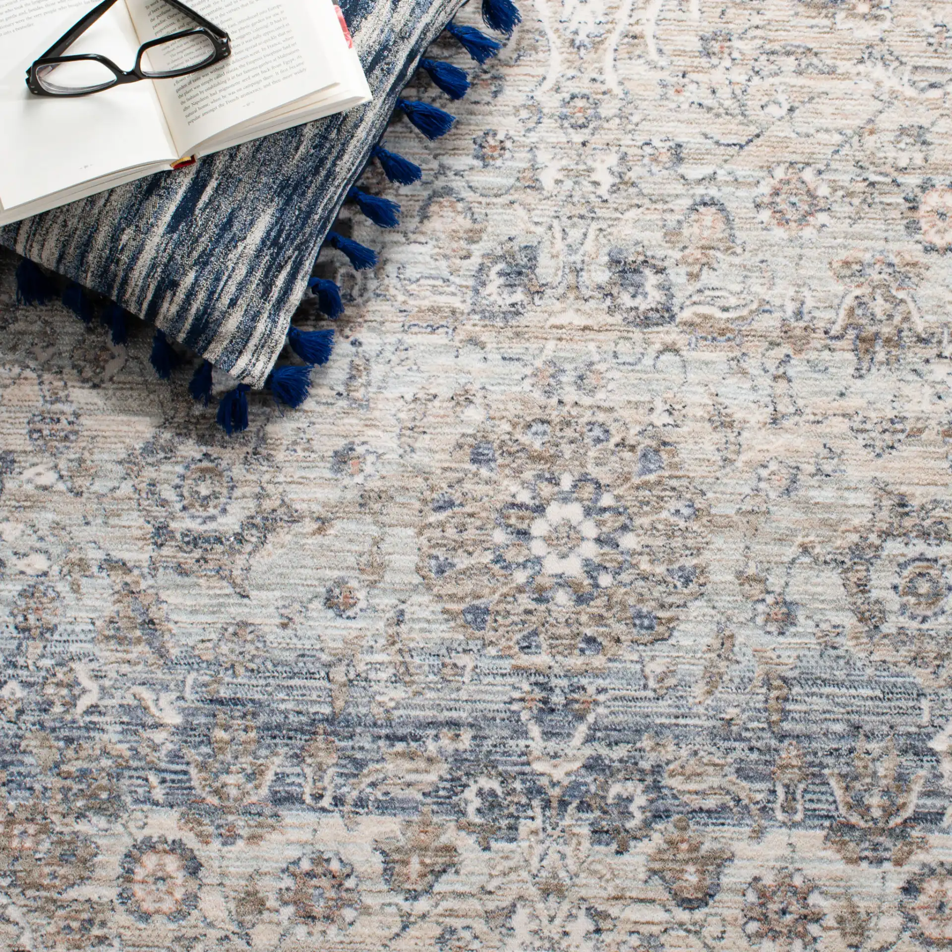 Moondust Faded Floral Bordered Rug in Beige / Gray in a styled room