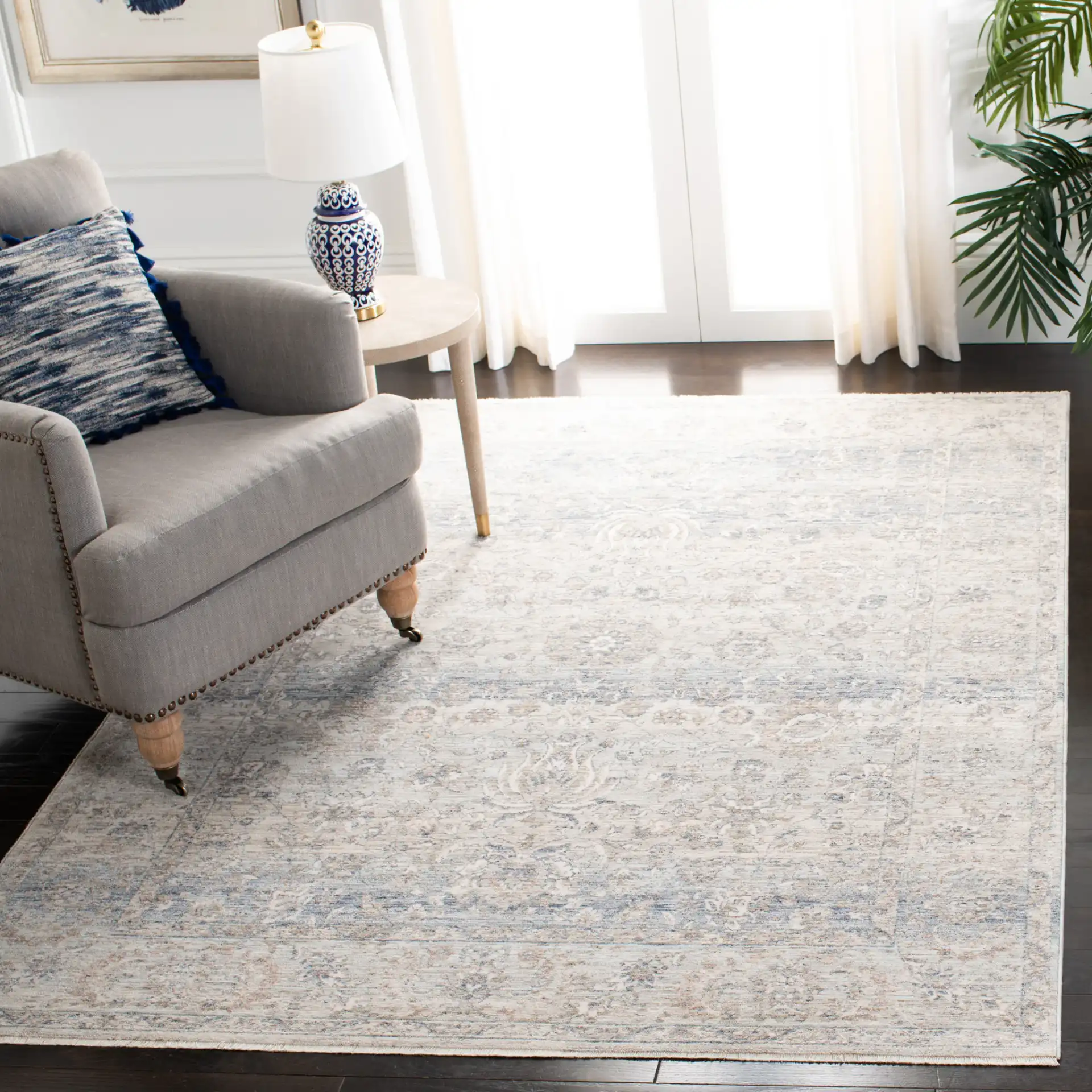 Moondust Faded Floral Bordered Rug in Beige / Gray in a styled room