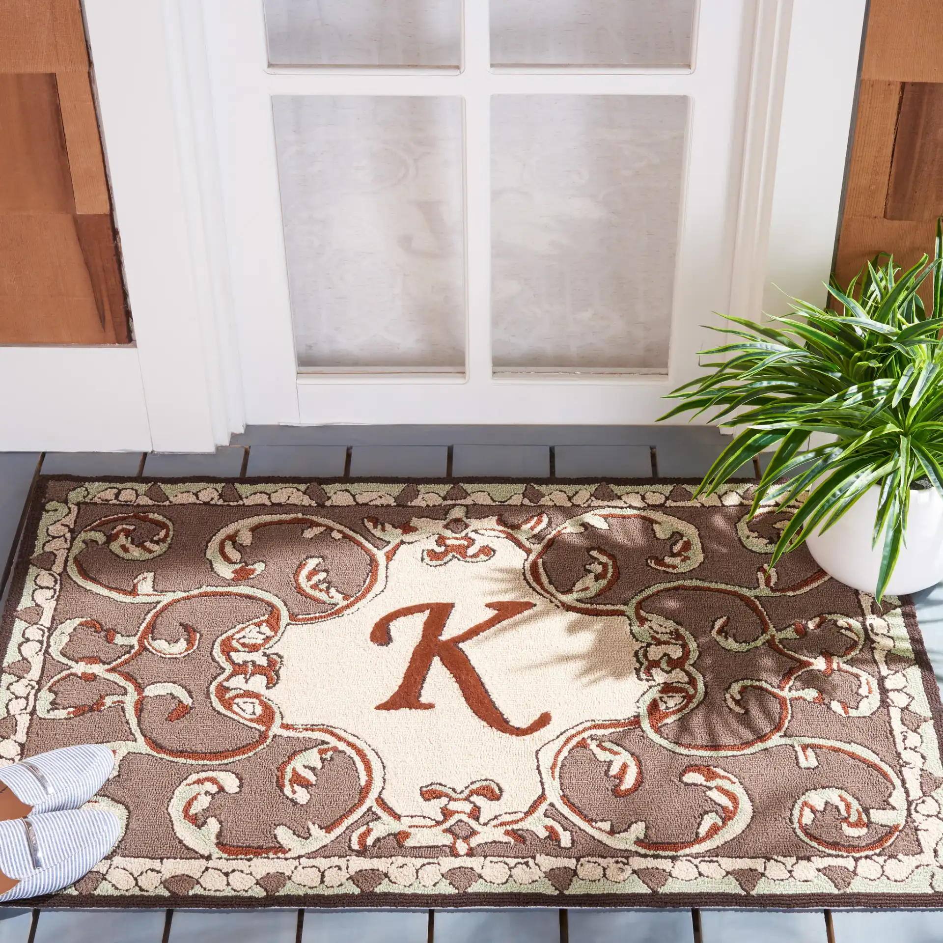 Monogram Scrollwork Outdoor Rug in Mocha in a styled room