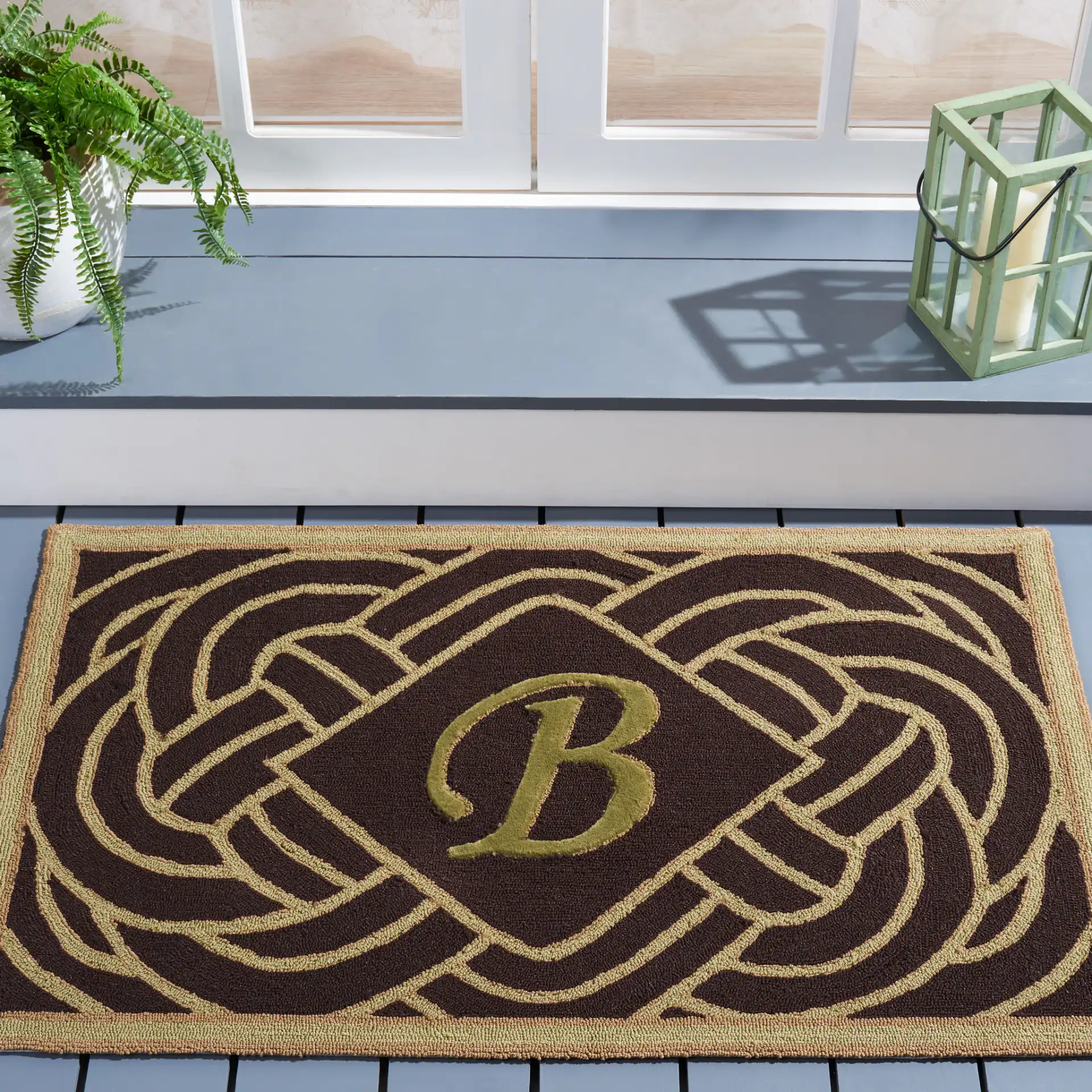 Monogram Knot Outdoor Rug in Chocolate in a styled room
