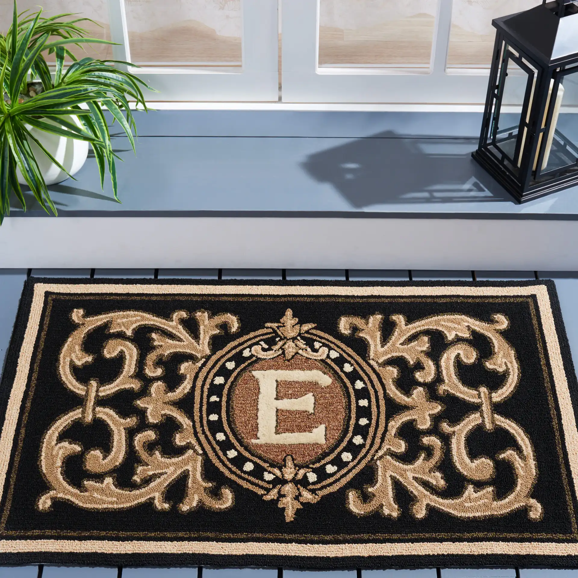 Monogram Berkeley Scrollwork Hand-Hooked Outdoor Rug in Black in a styled room