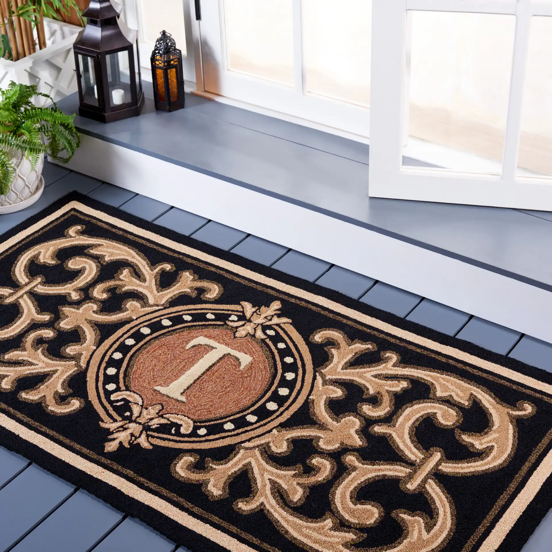 Monogram Berkeley Scrollwork Hand-Hooked Outdoor Rug in Black in a styled room