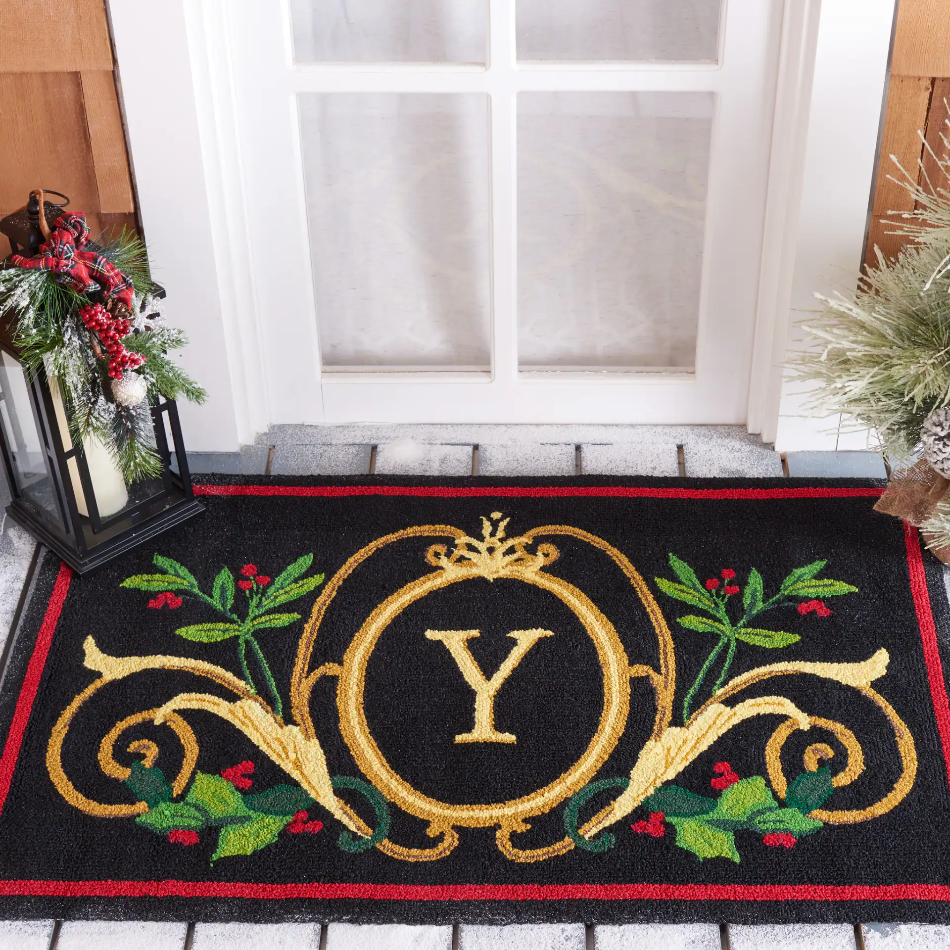 Monogram Crest Hand-Hooked Outdoor Rug in Black / Multicolor in a styled room