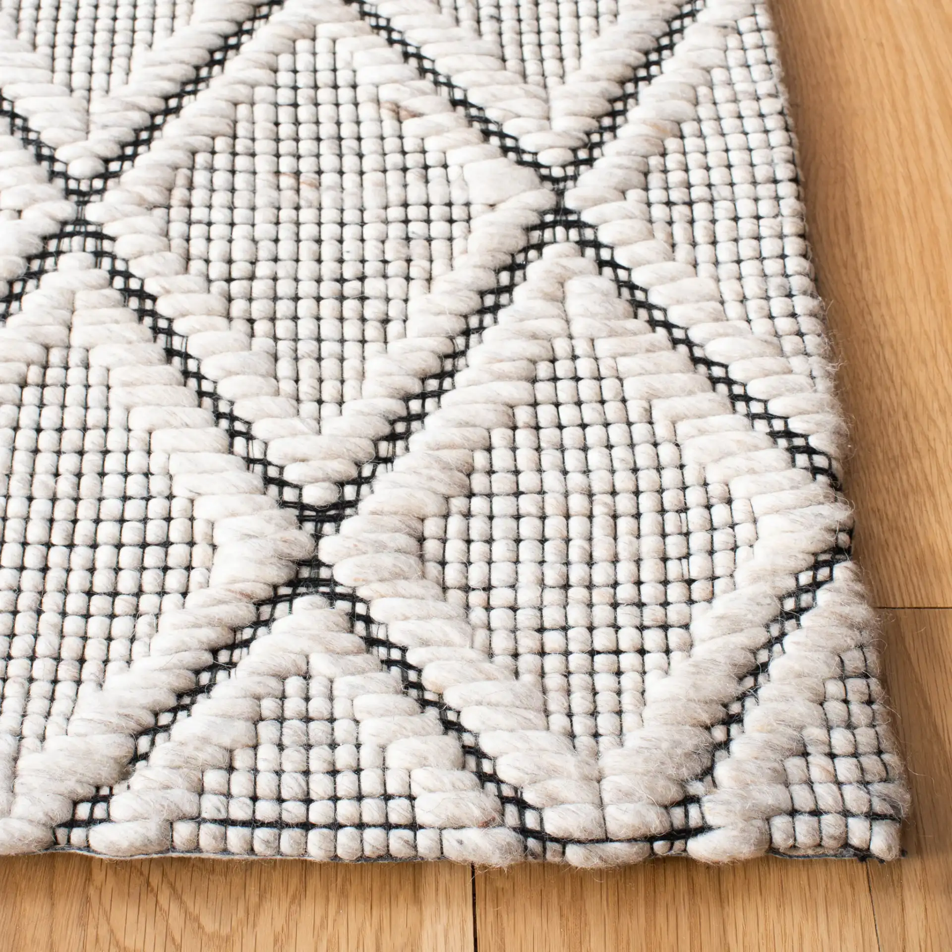 Marbella Diamond Trellis Hand-Woven Wool Rug in Silver / Black in a styled room