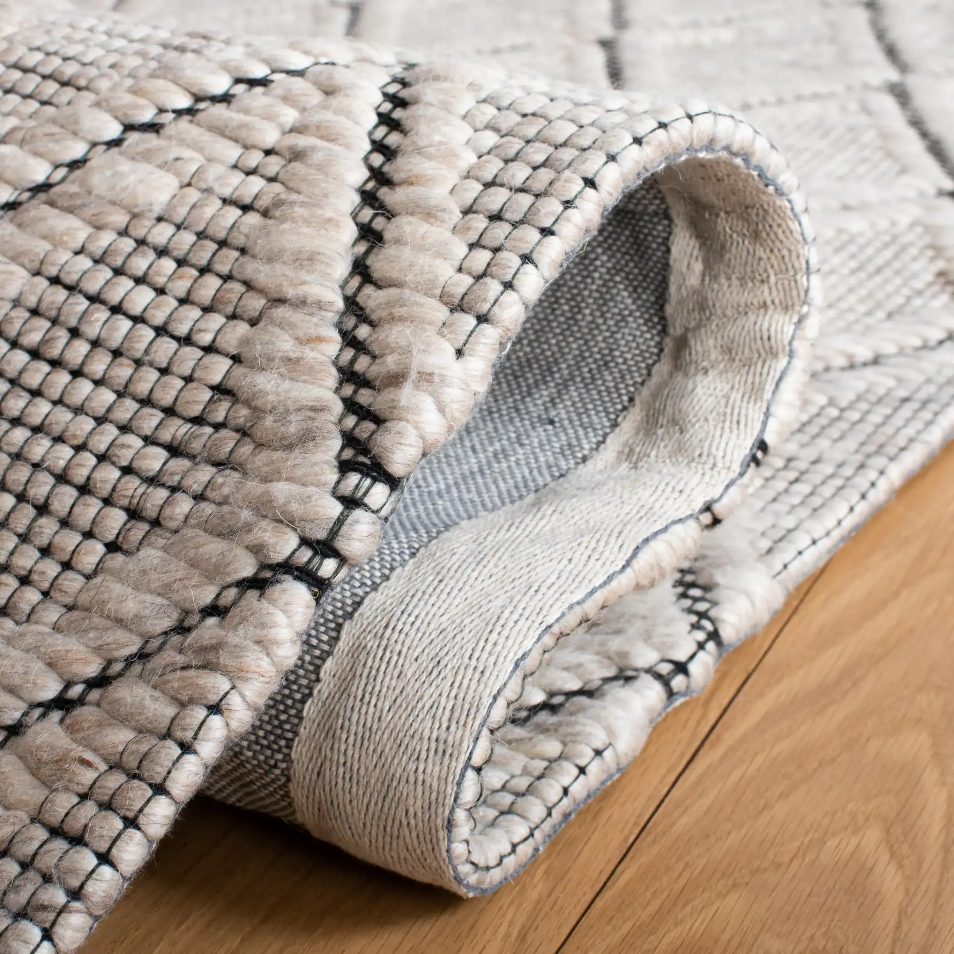 Marbella Diamond Trellis Hand-Woven Wool Rug in Silver / Black in a styled room