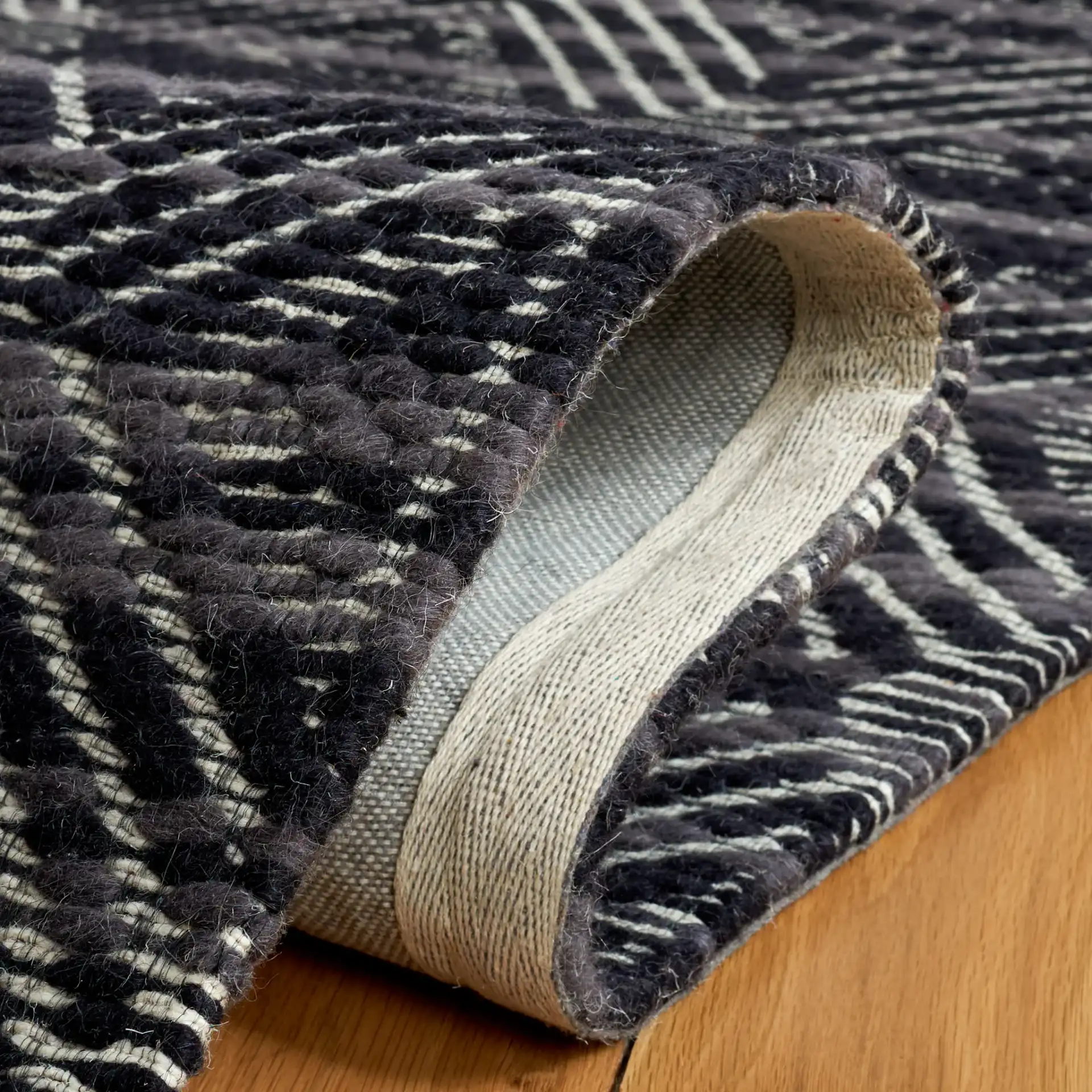Marbella Hampshire Concentric Diamond Hand-Loomed Wool Rug in Black / Ivory in a styled room