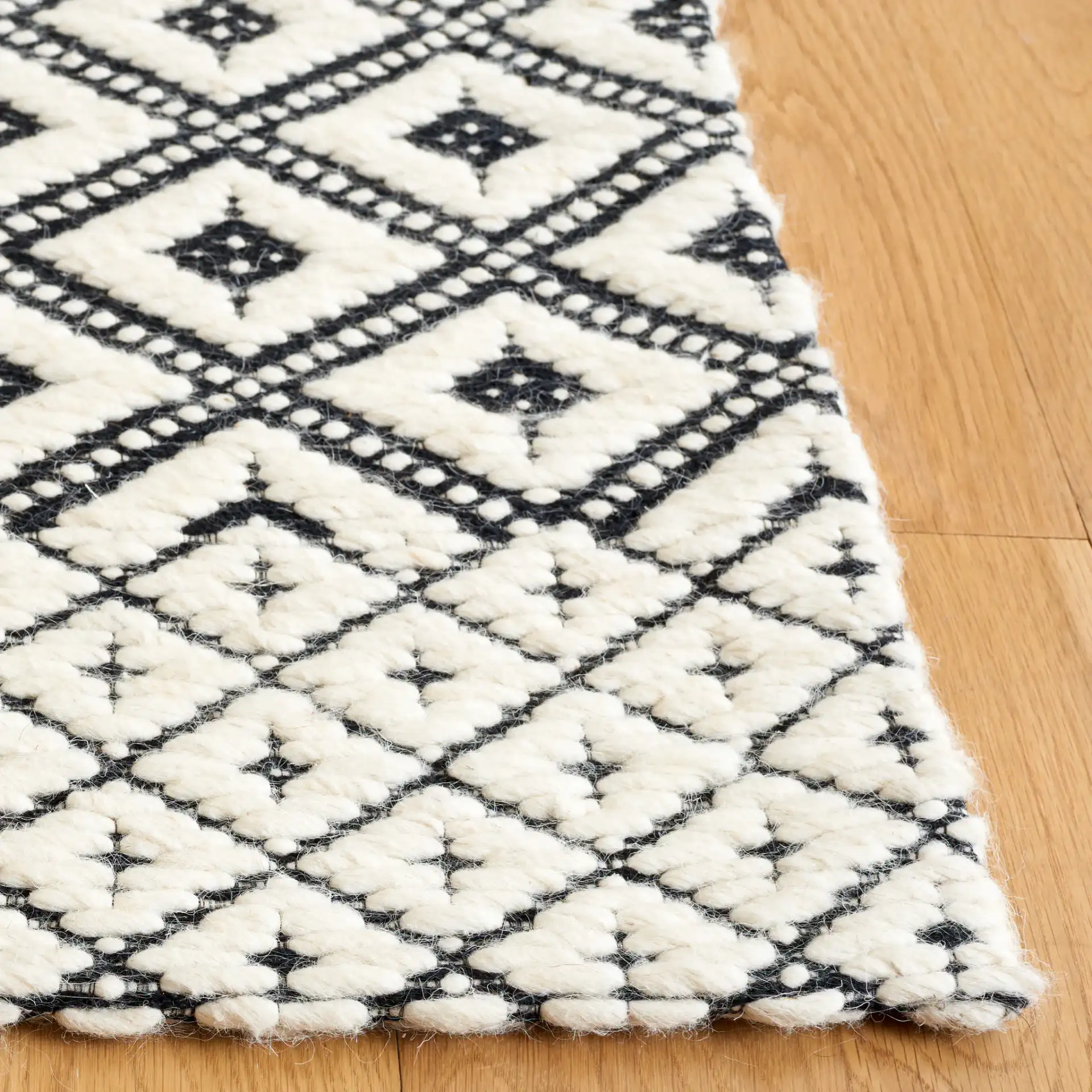 Marbella Kenza Diamond Lattice Hand-Loomed Wool Rug in Black / Ivory in a styled room