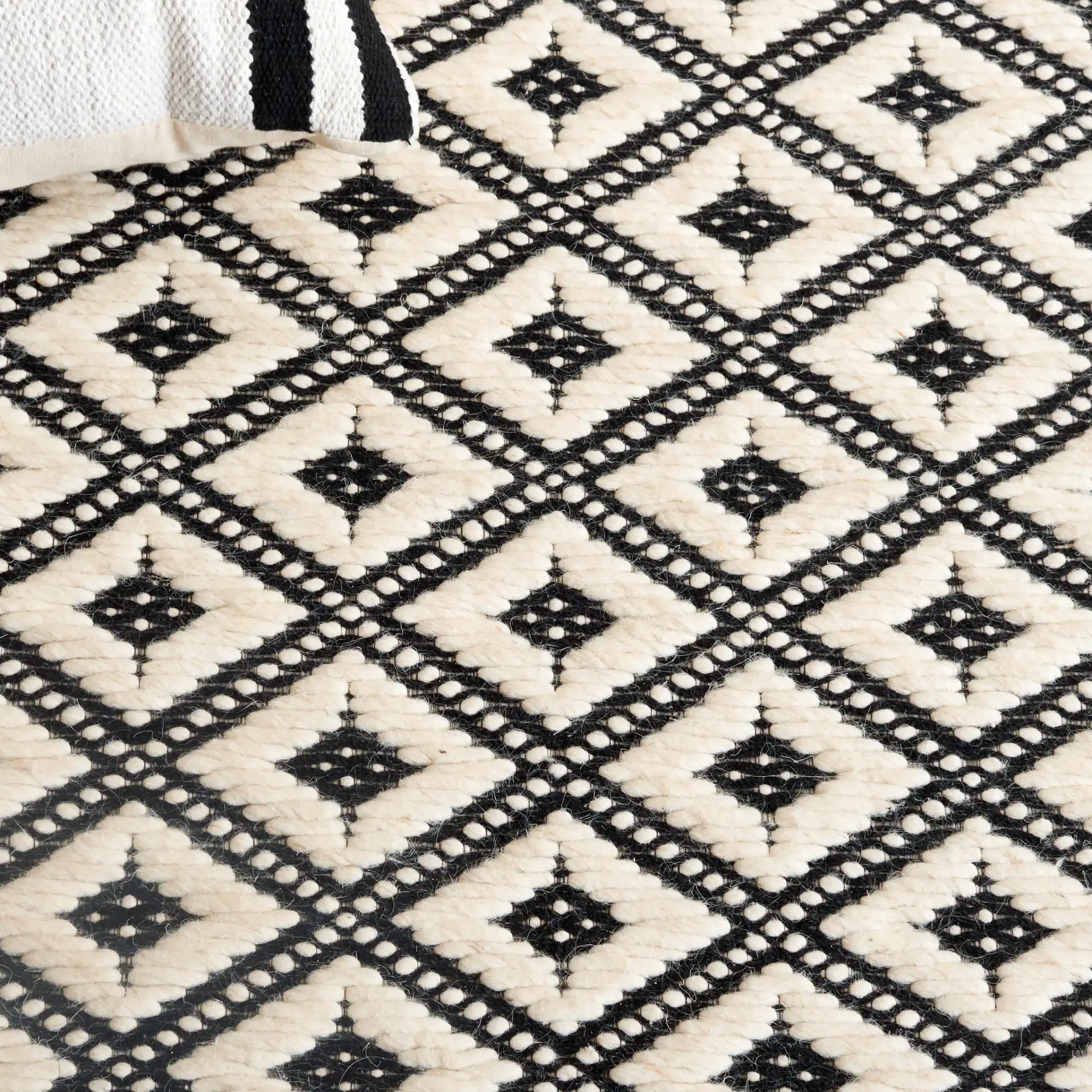 Marbella Kenza Diamond Lattice Hand-Loomed Wool Rug in Black / Ivory in a styled room