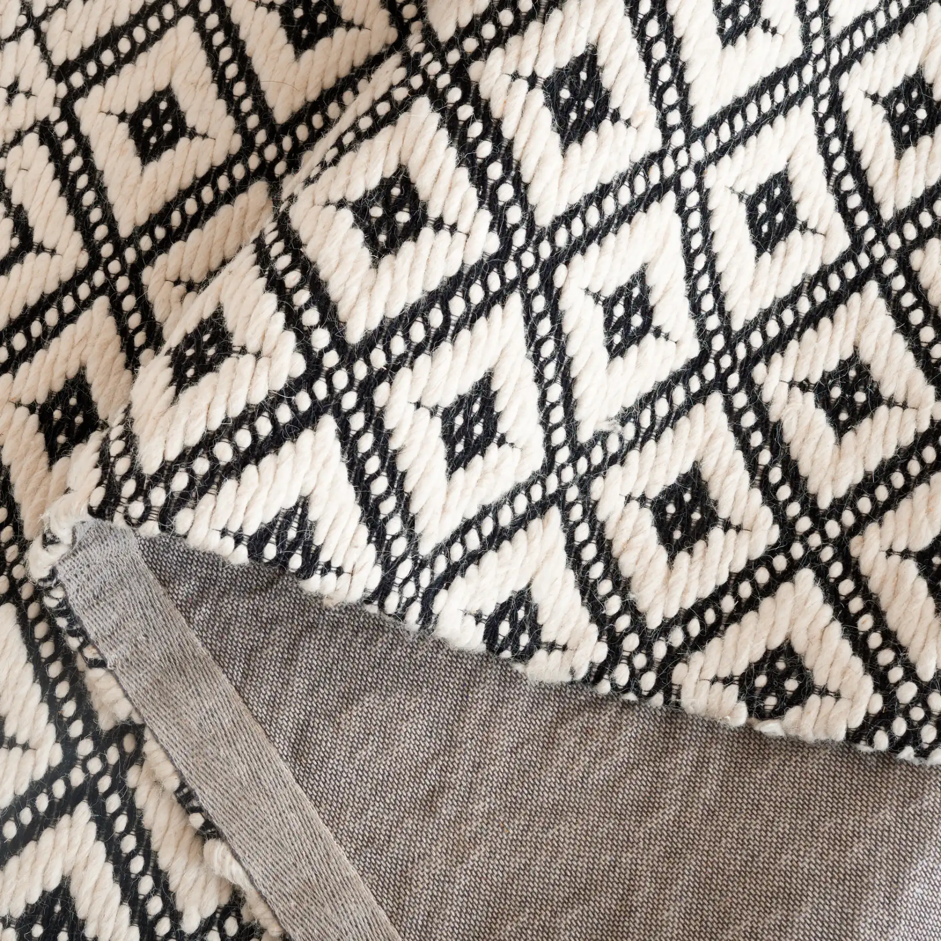 Marbella Kenza Diamond Lattice Hand-Loomed Wool Rug in Black / Ivory in a styled room