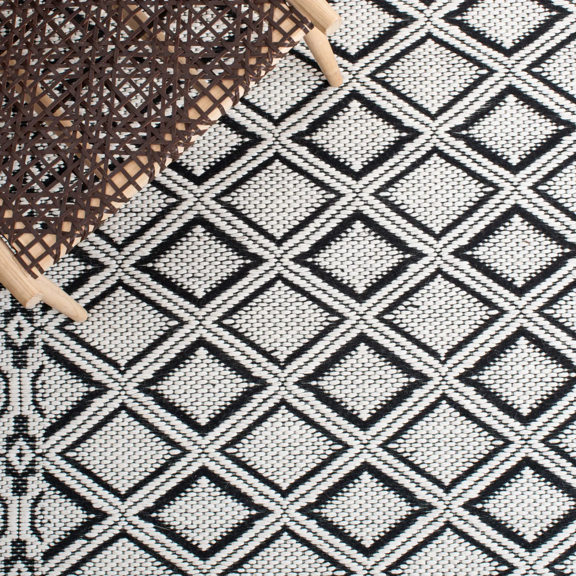Marbella Diamond Border Hand-Woven Wool Rug in Ivory / Black in a styled room