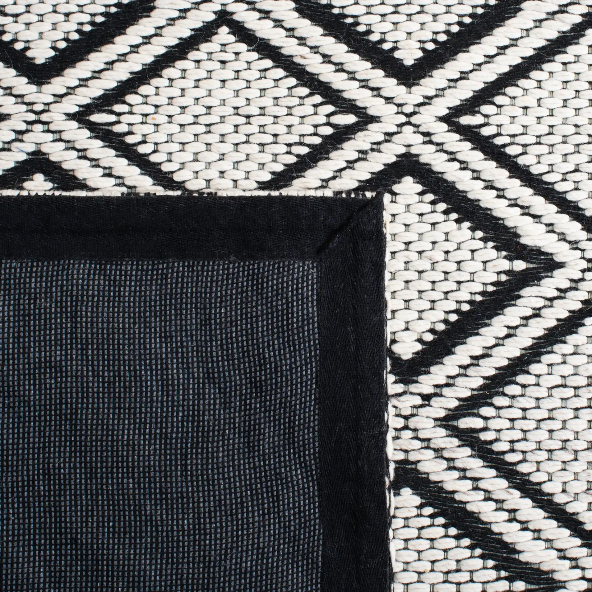 Marbella Diamond Border Hand-Woven Wool Rug in Ivory / Black in a styled room