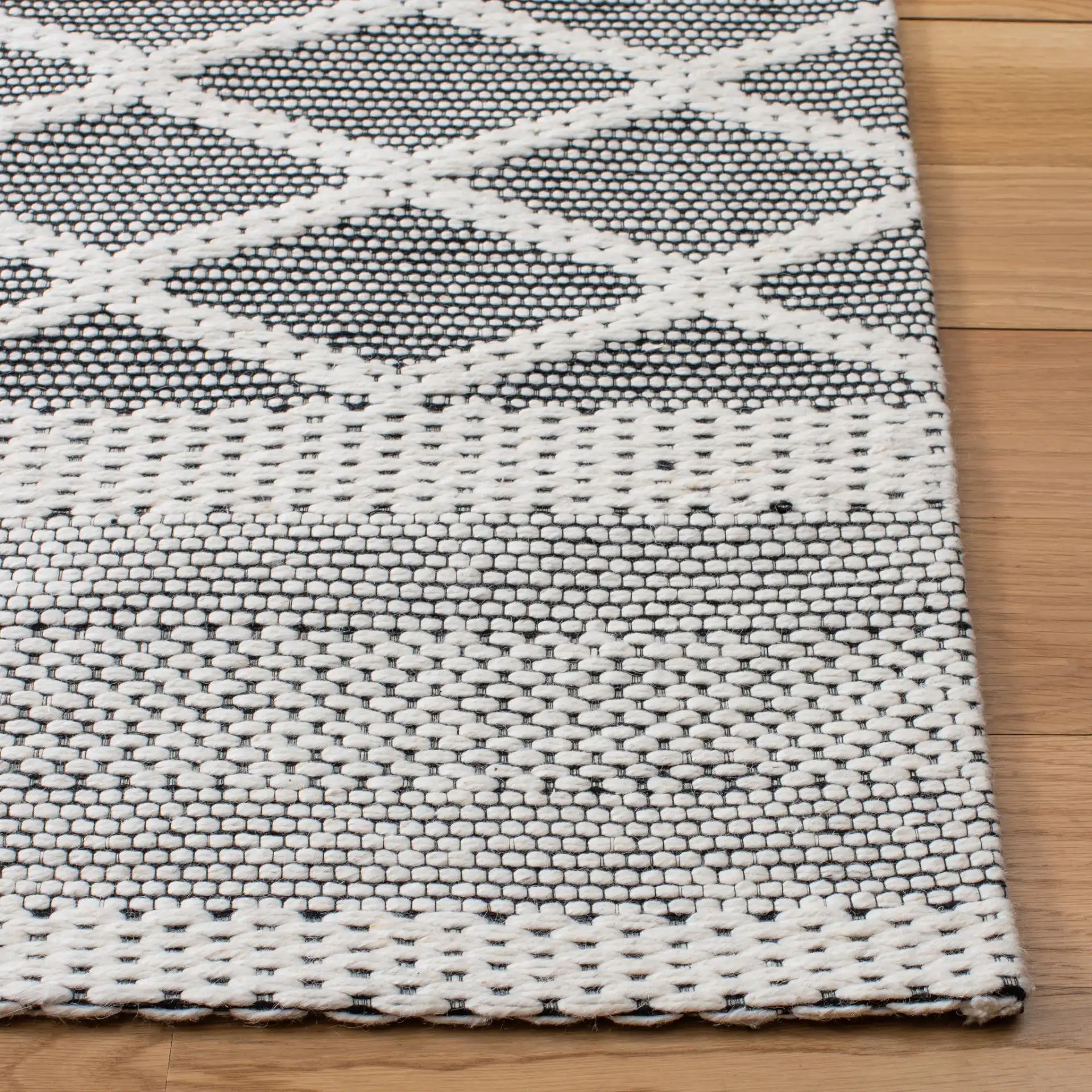 Marbella Banded Diamond Lattice Hand-Woven Wool Rug in Ivory / Black in a styled room