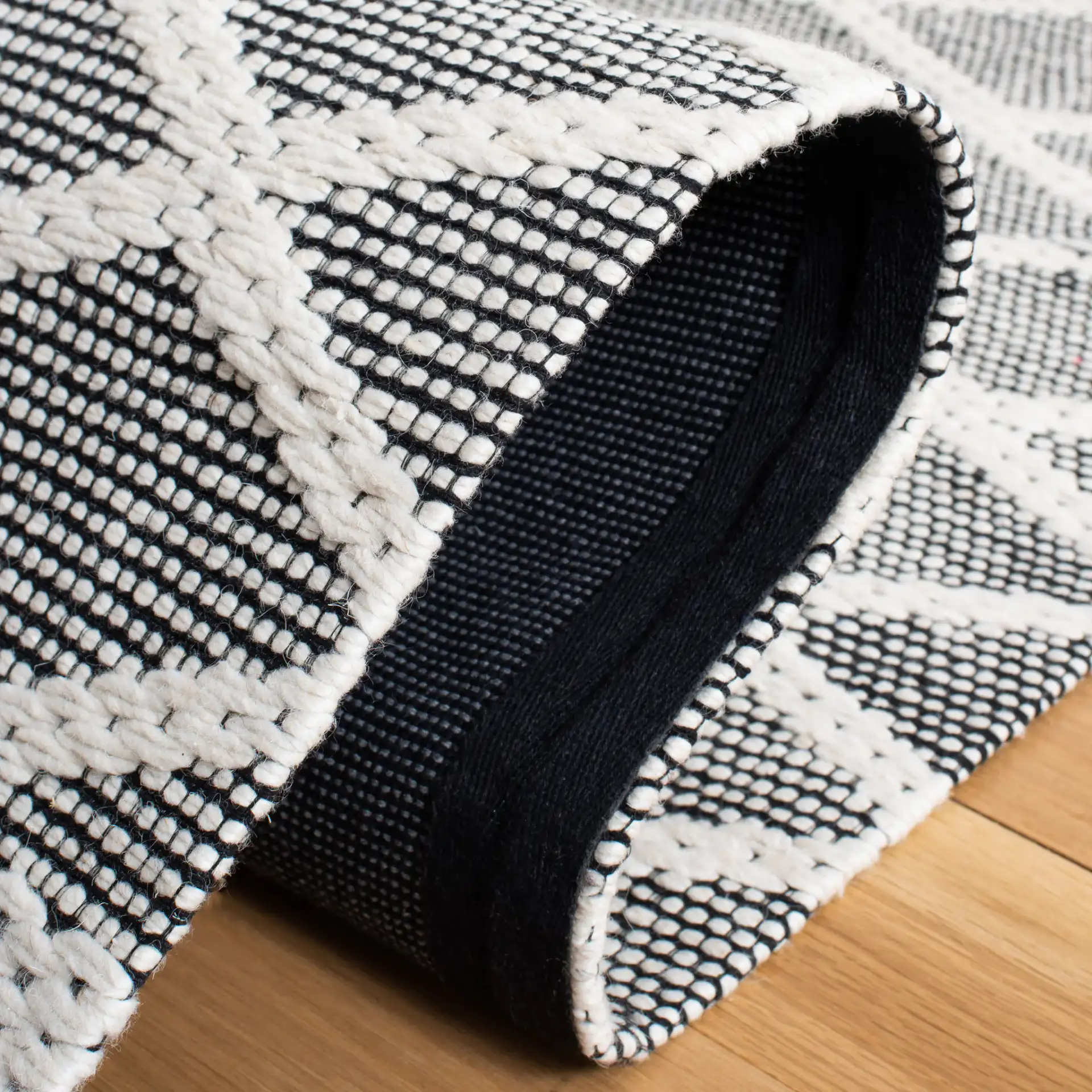 Marbella Banded Diamond Lattice Hand-Woven Wool Rug in Ivory / Black in a styled room