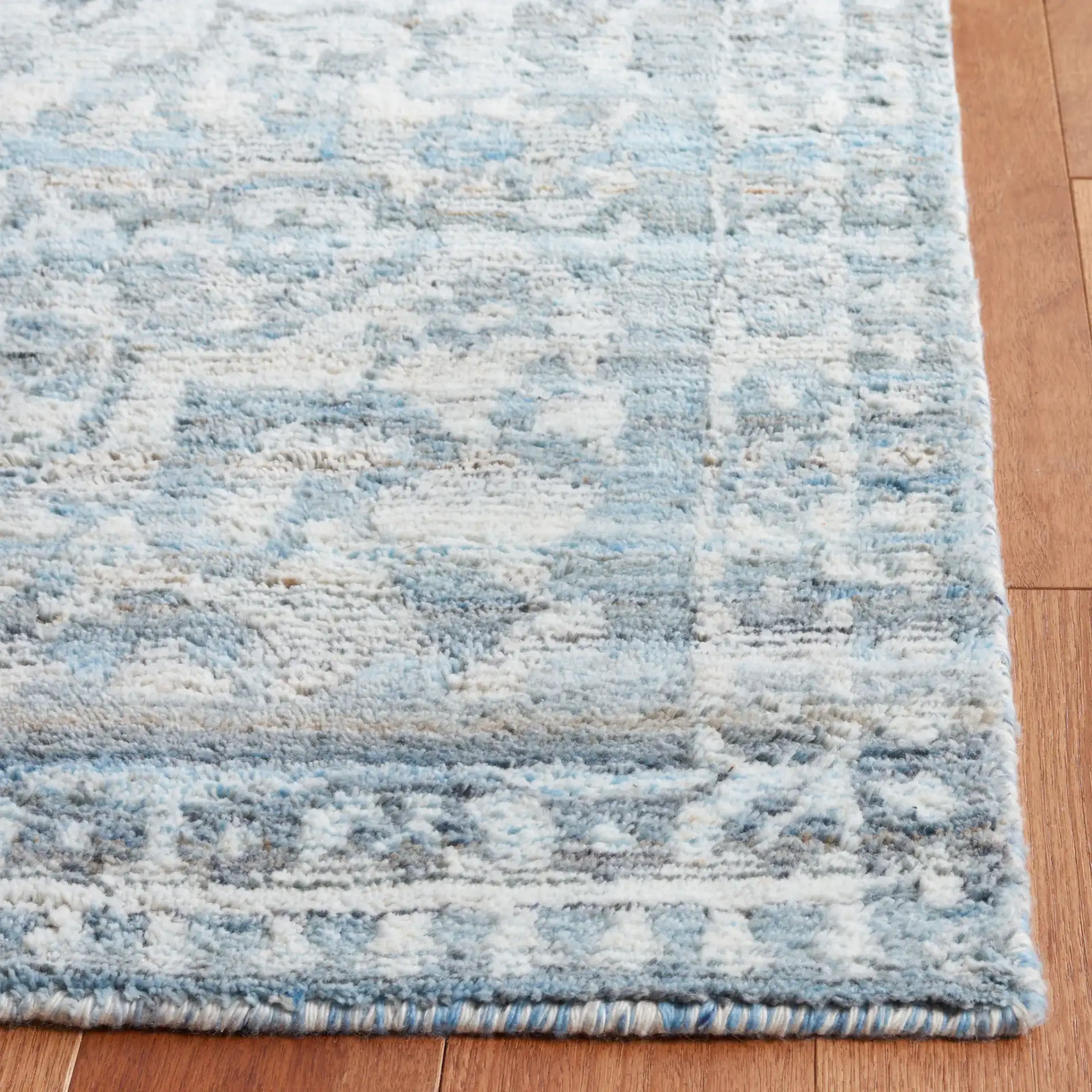 Marquee Faded Damask Hand-Tufted Rug in Blue / Gray in a styled room