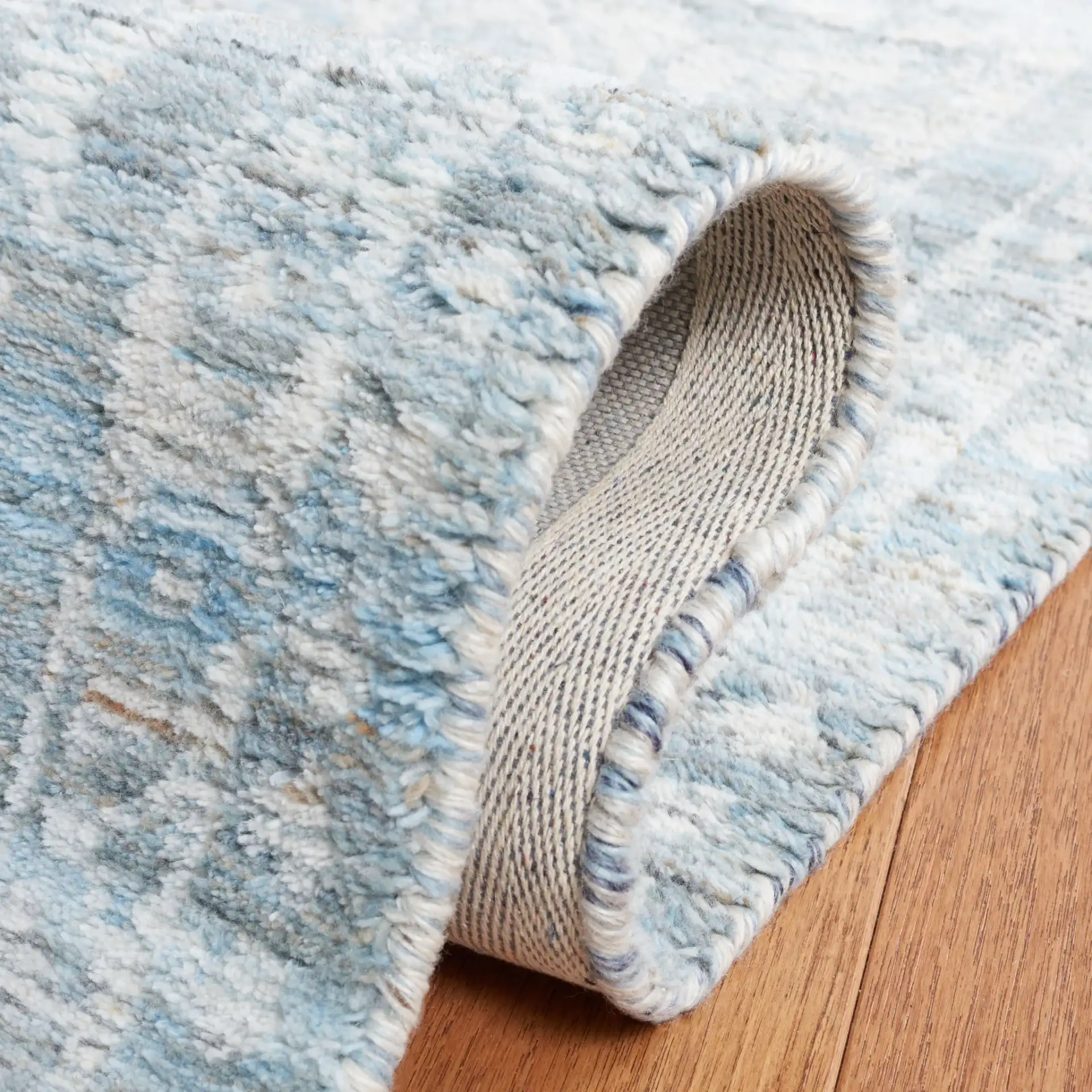 Marquee Faded Damask Hand-Tufted Rug in Blue / Gray in a styled room