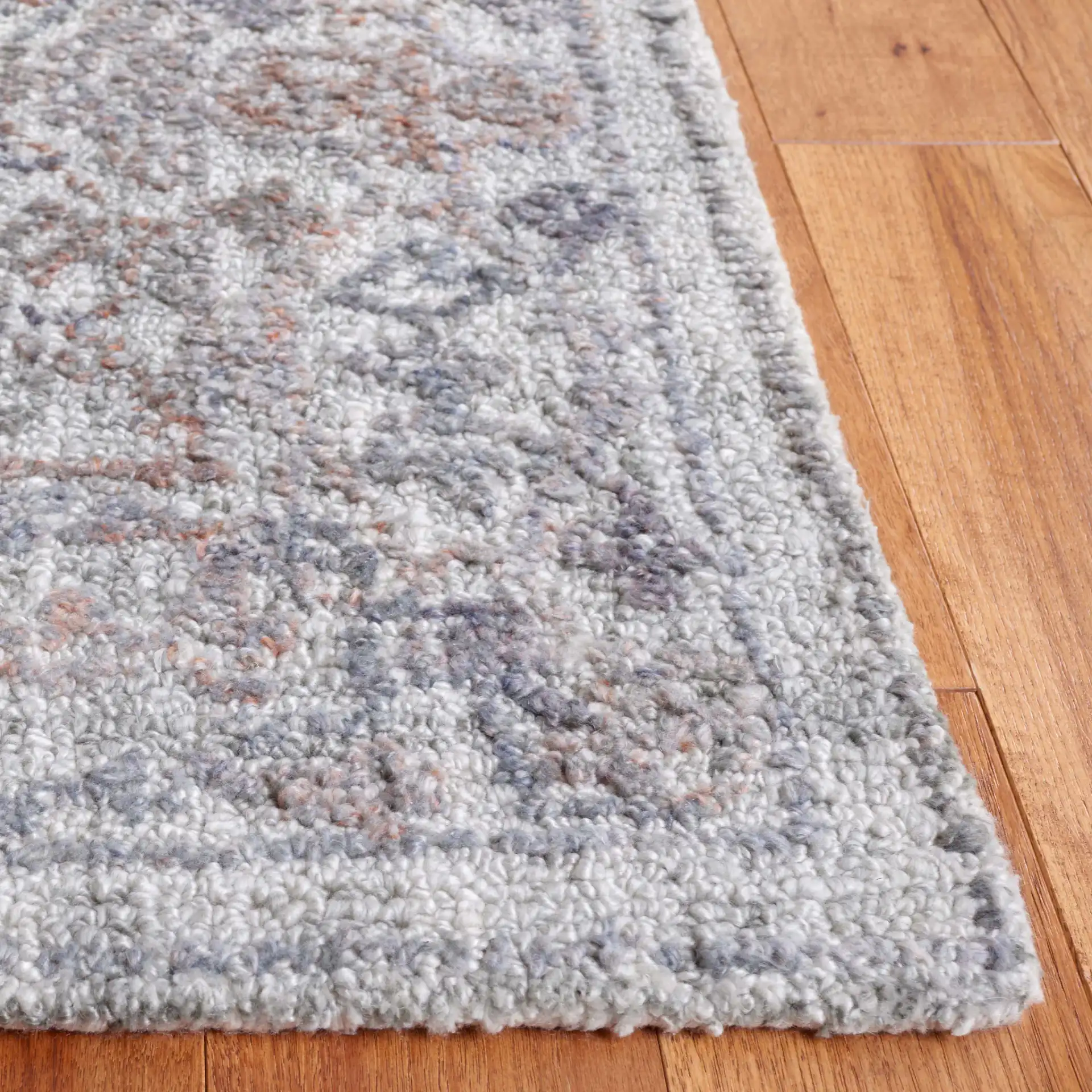 Marquee Distressed Floral Hand-Tufted Rug in Rust / Gray in a styled room