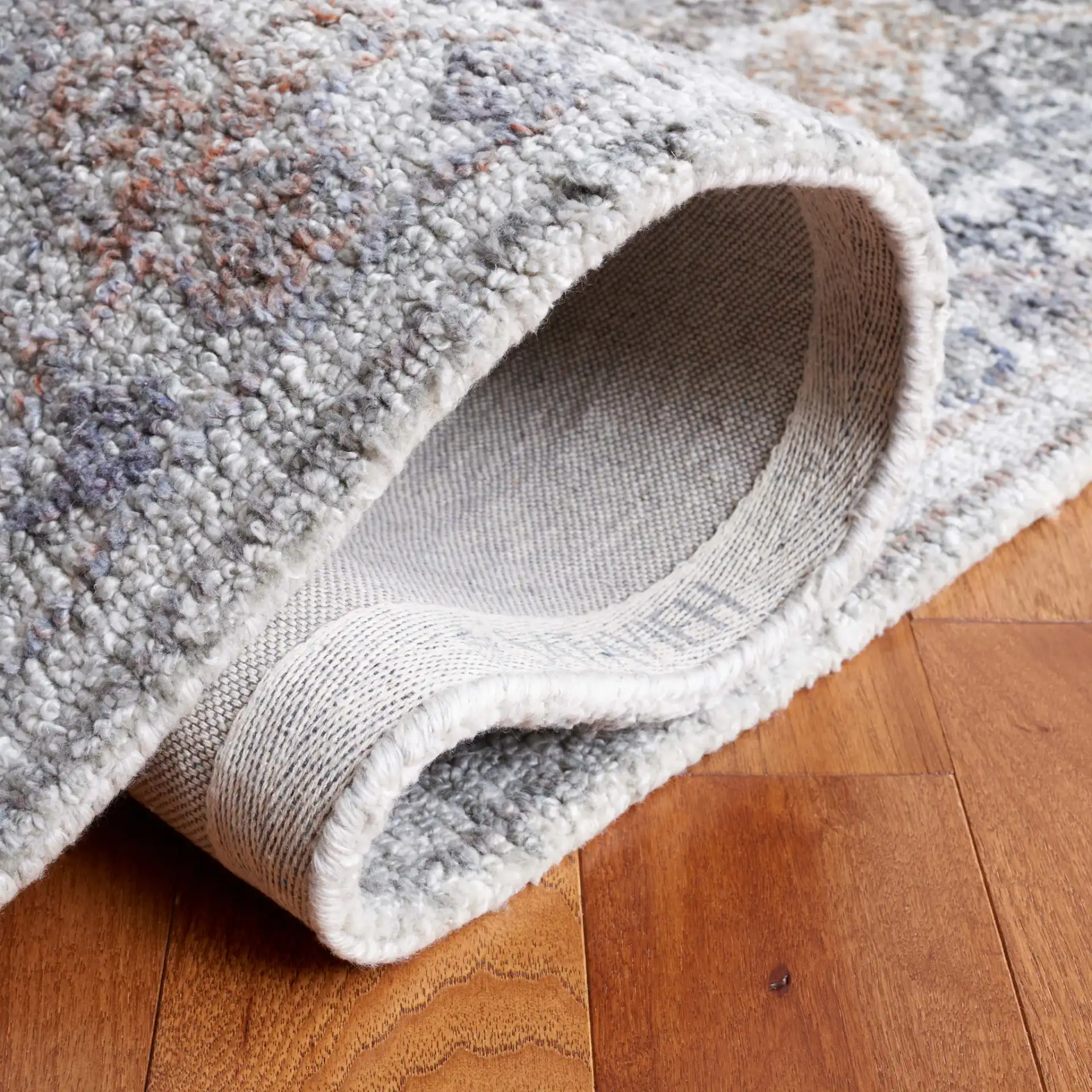 Marquee Distressed Floral Hand-Tufted Rug in Rust / Gray in a styled room