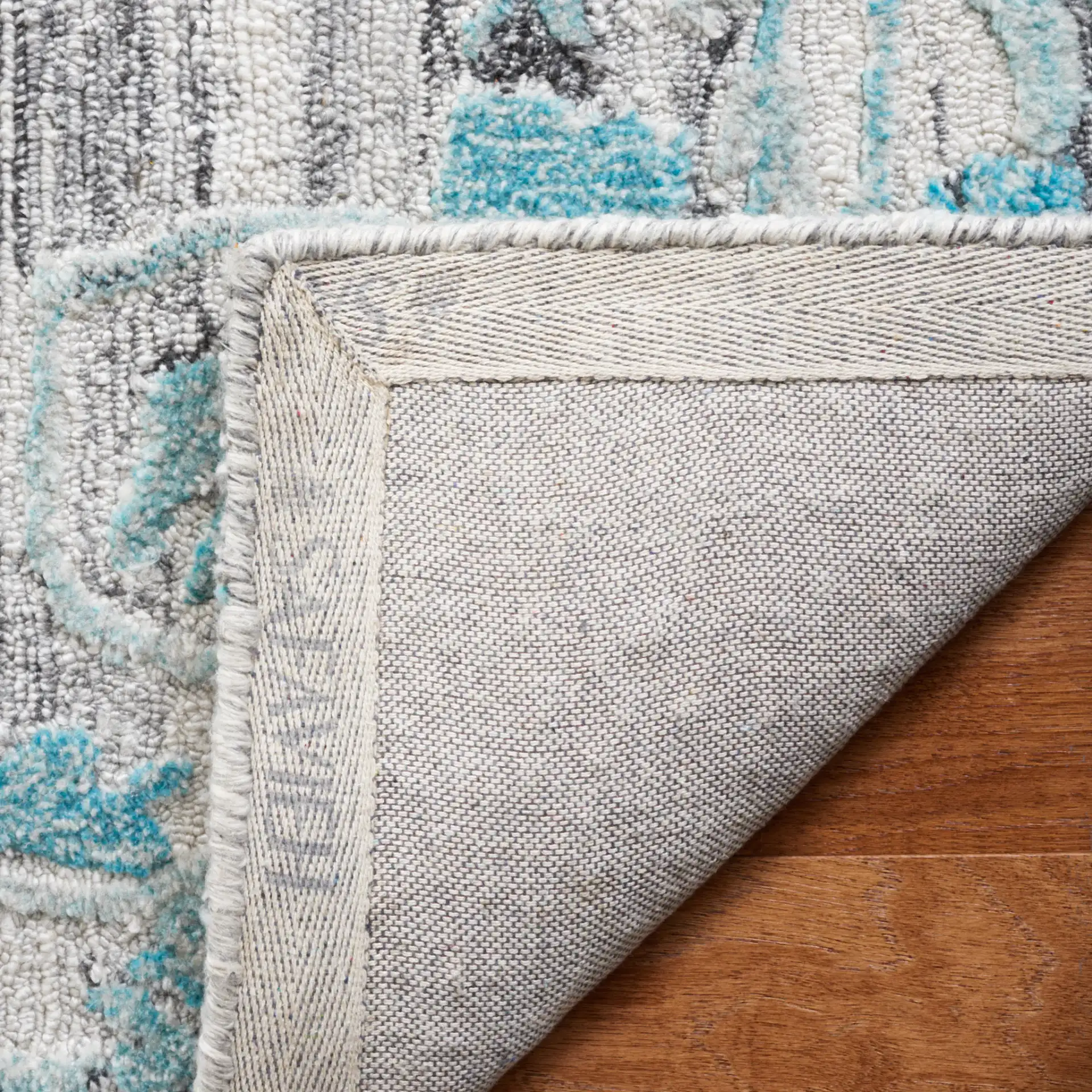 Marquee Striped Medallion Hand-Tufted Rug in Gray / Teal in a styled room