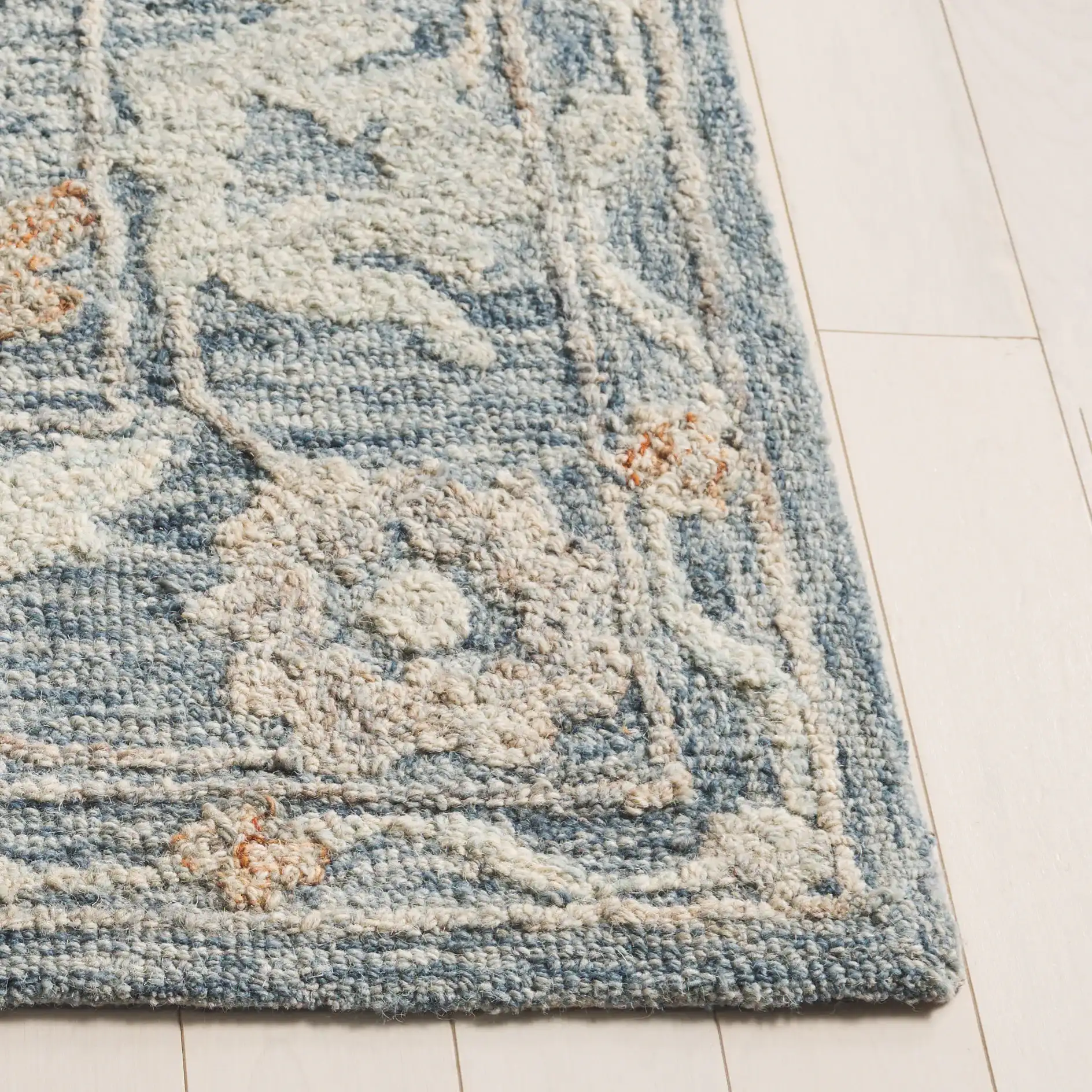 Marquee Oversized Floral Hand-Tufted Wool Rug in Blue / Rust in a styled room