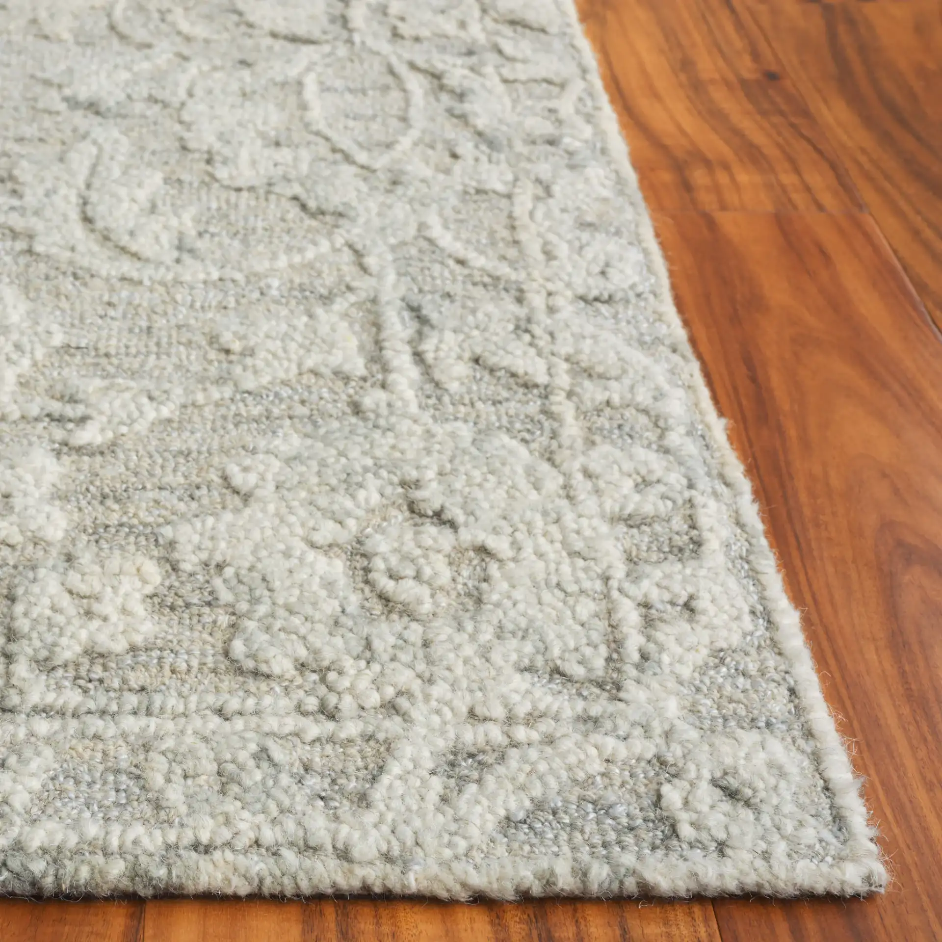 Marquee Floral Vine Bordered Hand-Tufted Rug in Gray / Ivory in a styled room