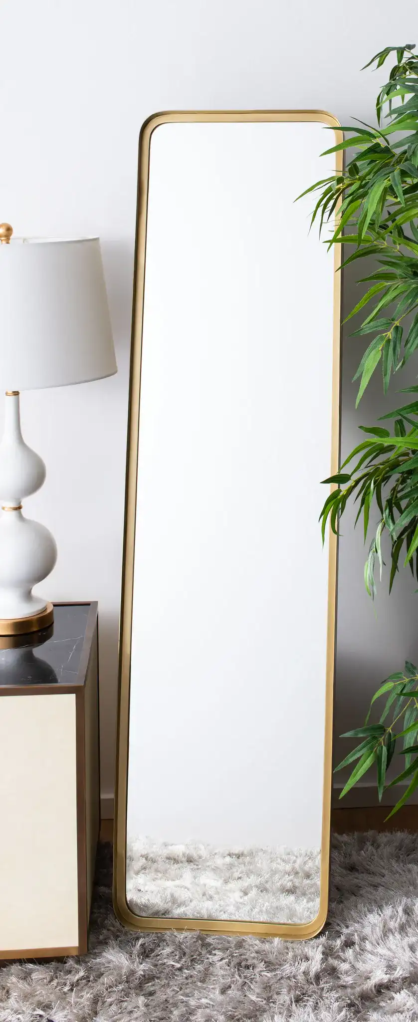 Lerna Mirror in Brushed Brass in a styled room