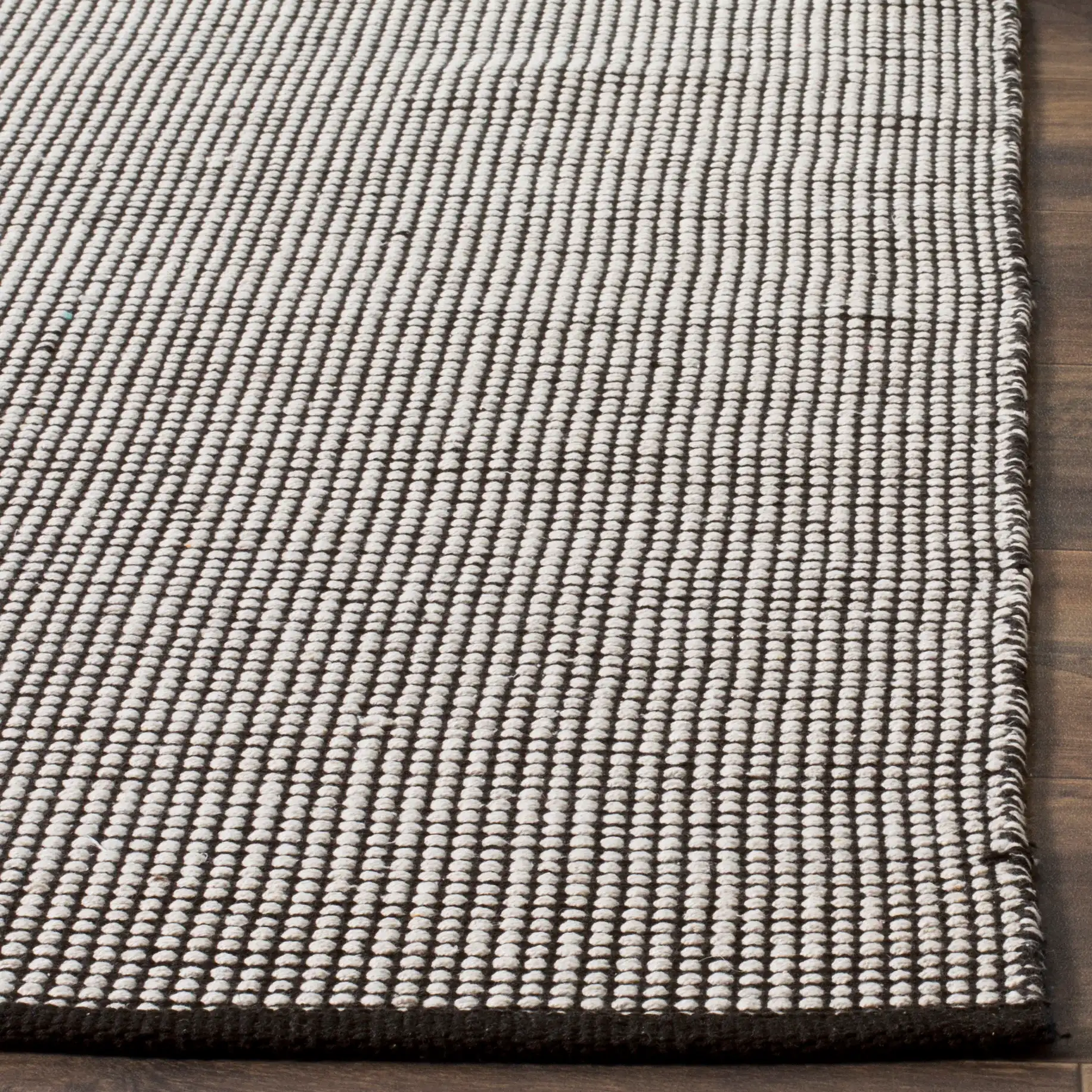 Montauk Grid Hand-Woven Cotton Rug in Ivory / Black in a styled room