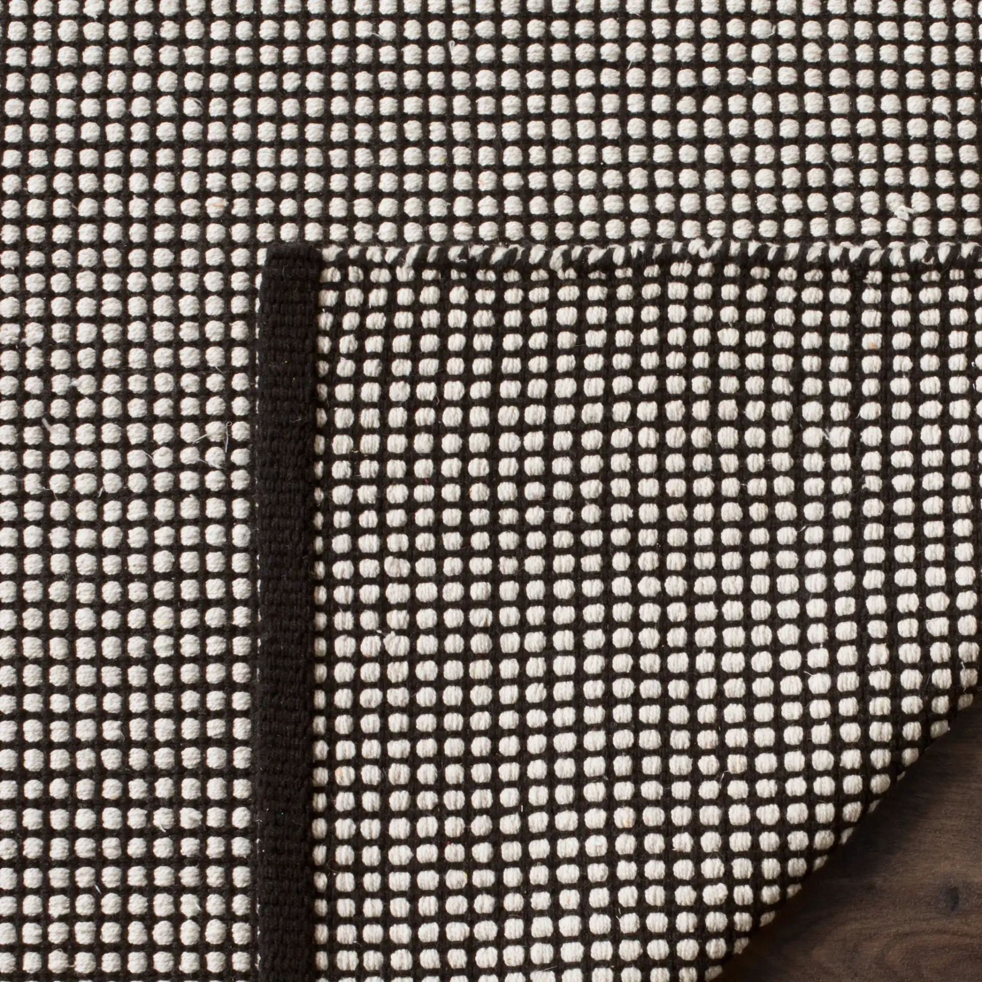 Montauk Grid Hand-Woven Cotton Rug in Ivory / Black in a styled room
