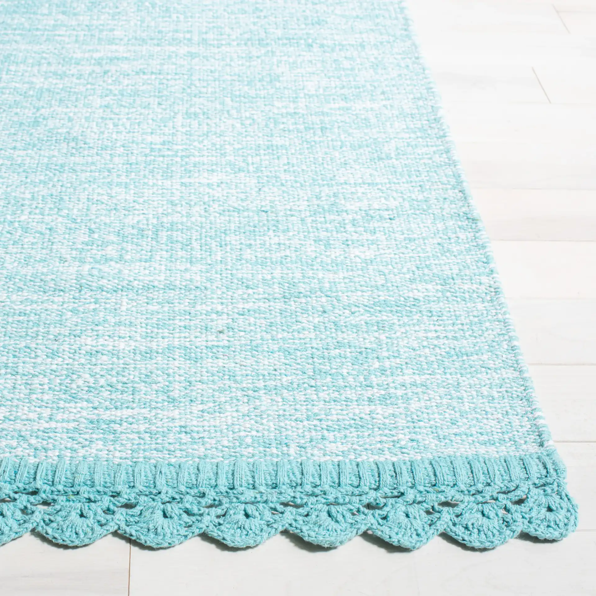 Montauk Scalloped Border Hand-Woven Cotton Rug in Turquoise in a styled room