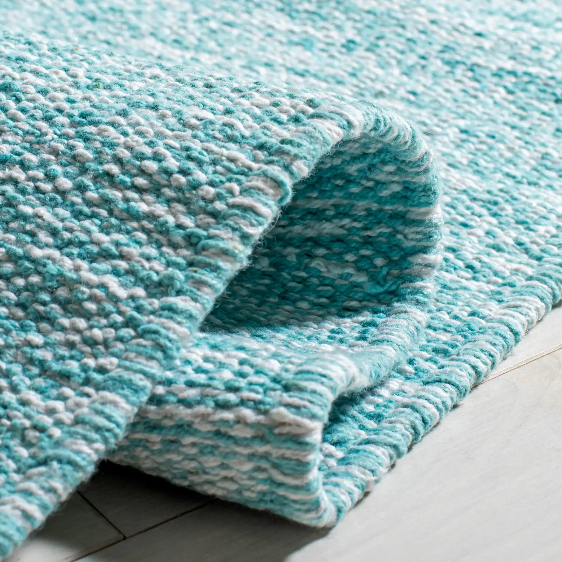 Montauk Scalloped Border Hand-Woven Cotton Rug in Turquoise in a styled room
