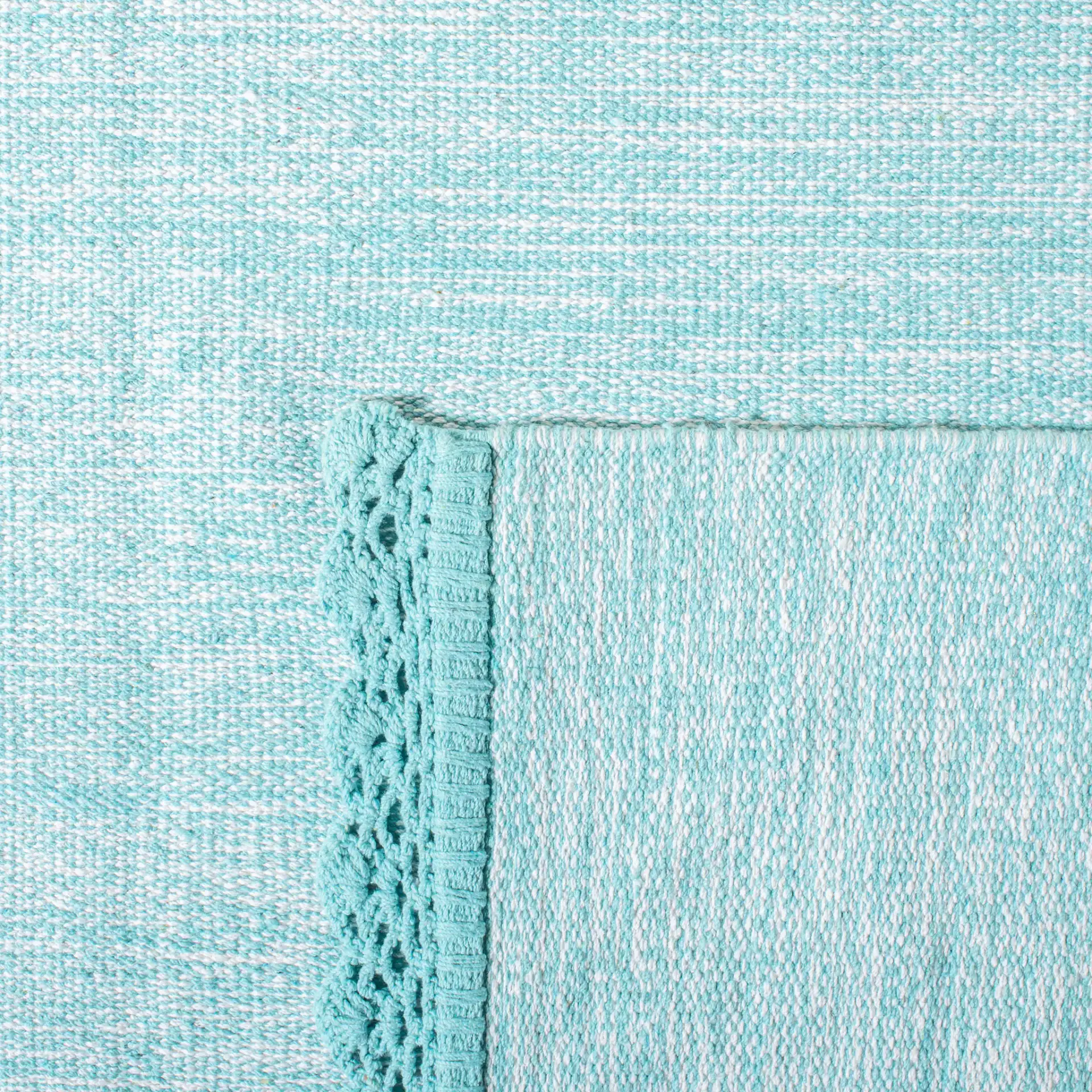 Montauk Scalloped Border Hand-Woven Cotton Rug in Turquoise in a styled room