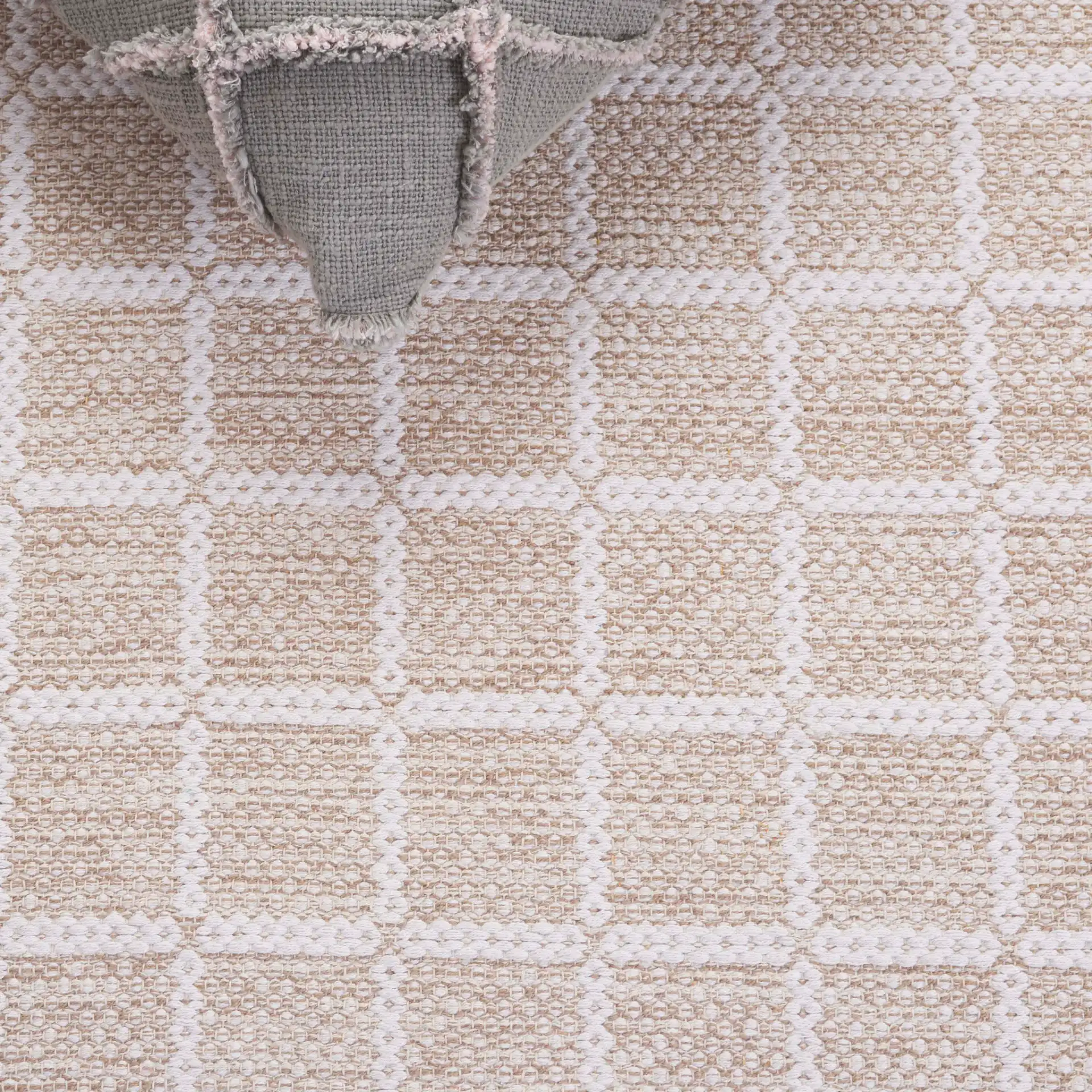 Montauk Waffle Grid Hand-Loomed Cotton Rug in Beige / Ivory in a styled room