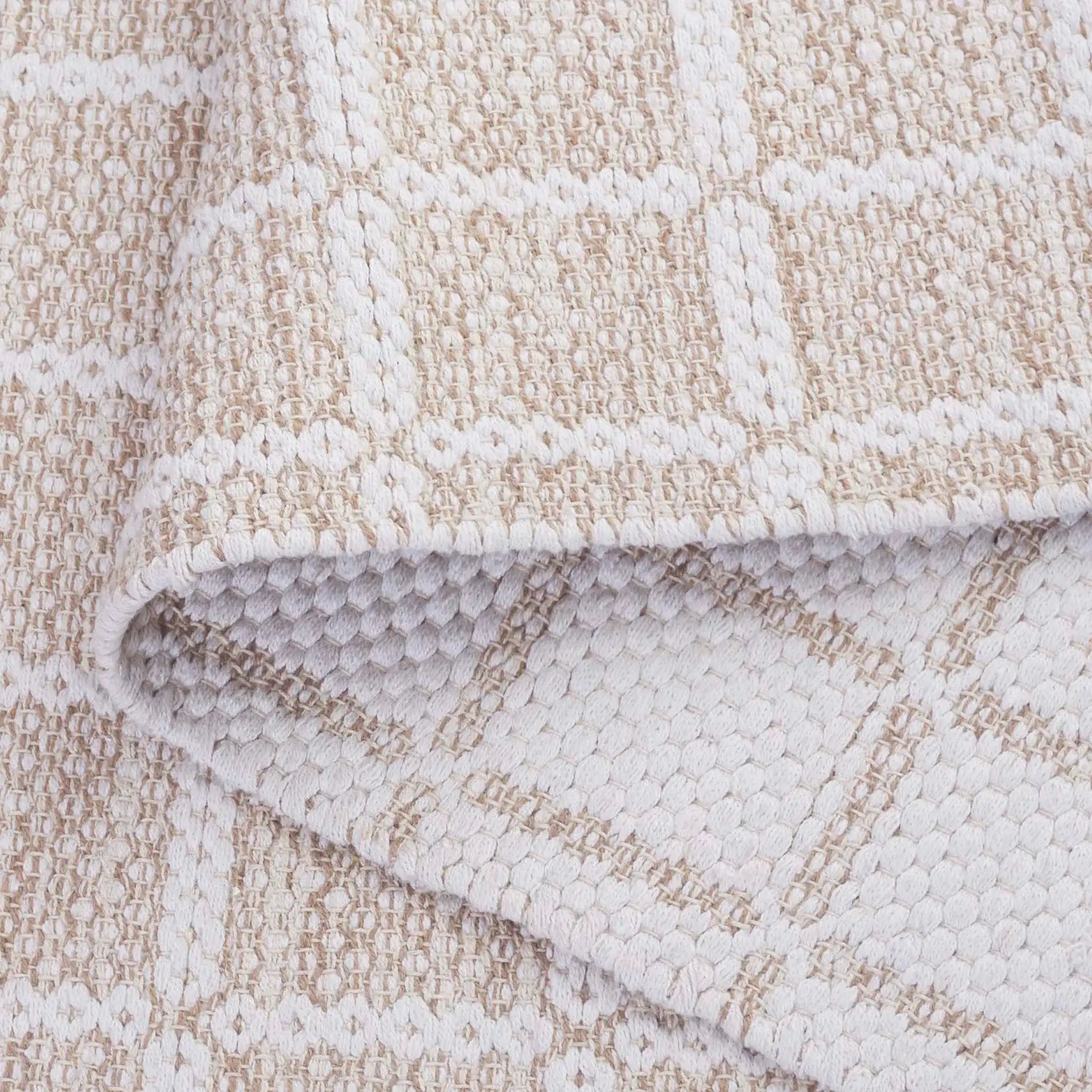 Montauk Waffle Grid Hand-Loomed Cotton Rug in Beige / Ivory in a styled room