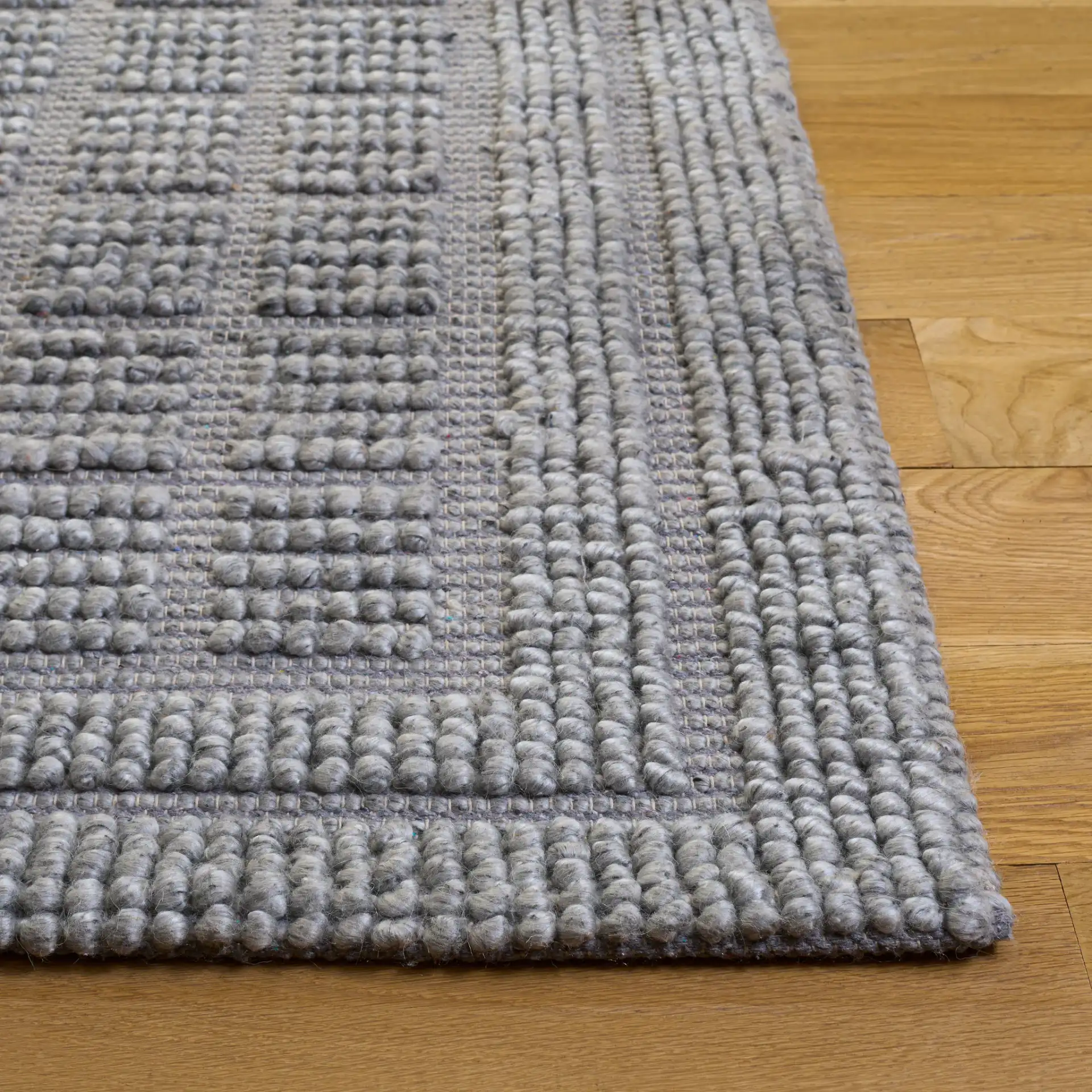 Natura Textured Grid Hand-Woven Rug in Gray in a styled room