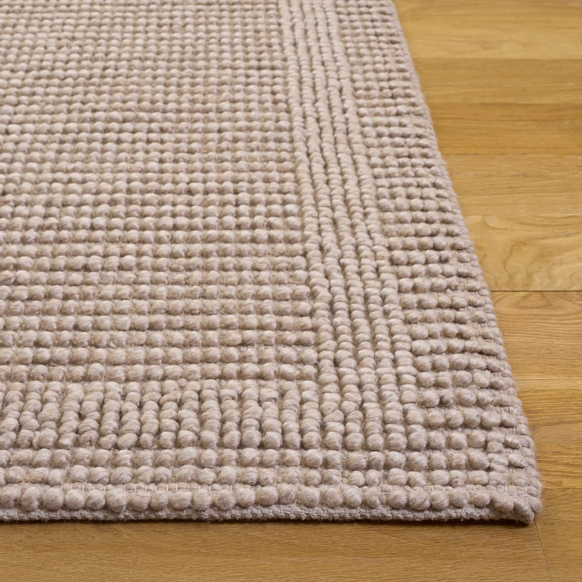 Natura Textured Bordered Hand-Woven Rug in Beige in a styled room
