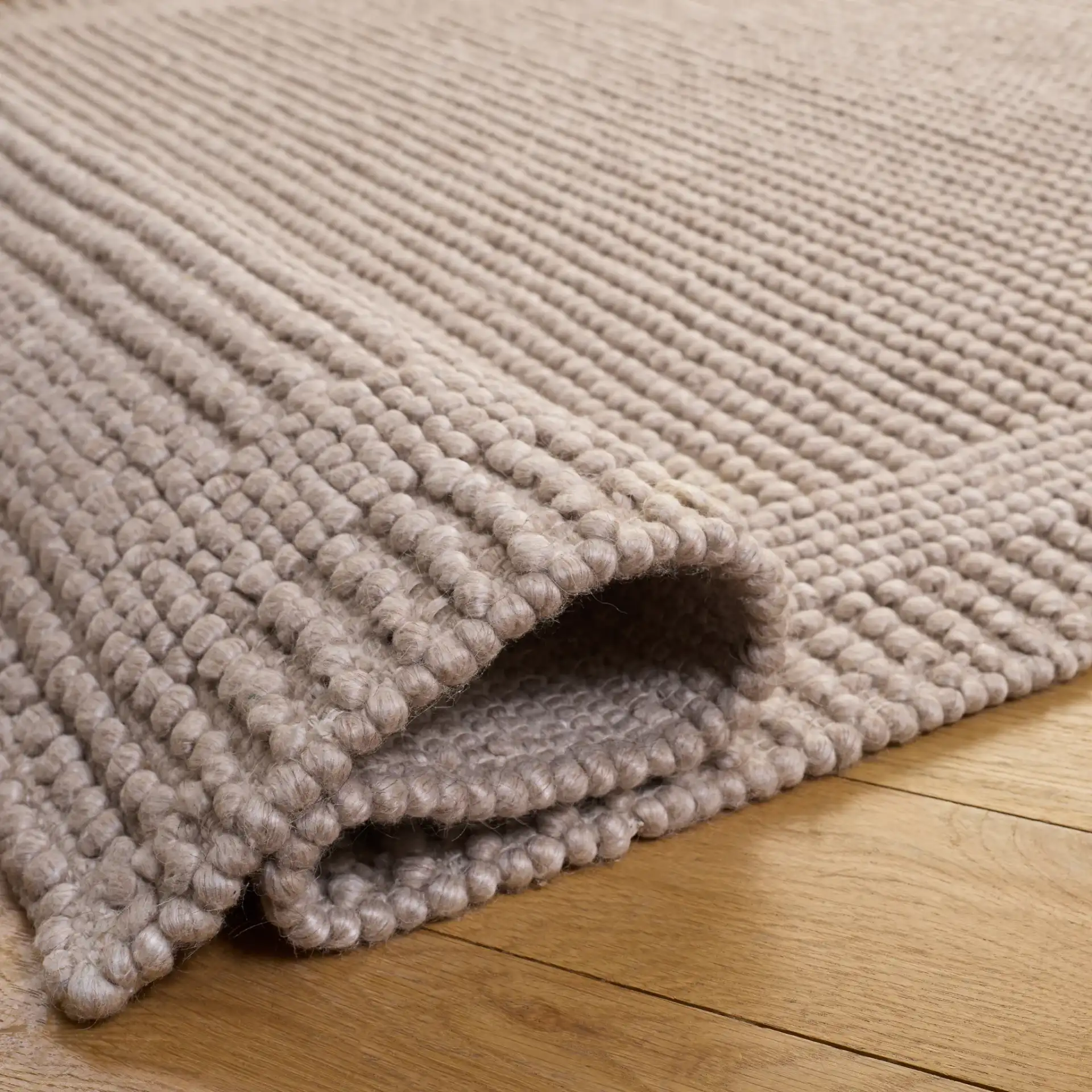 Natura Textured Bordered Hand-Woven Rug in Beige in a styled room
