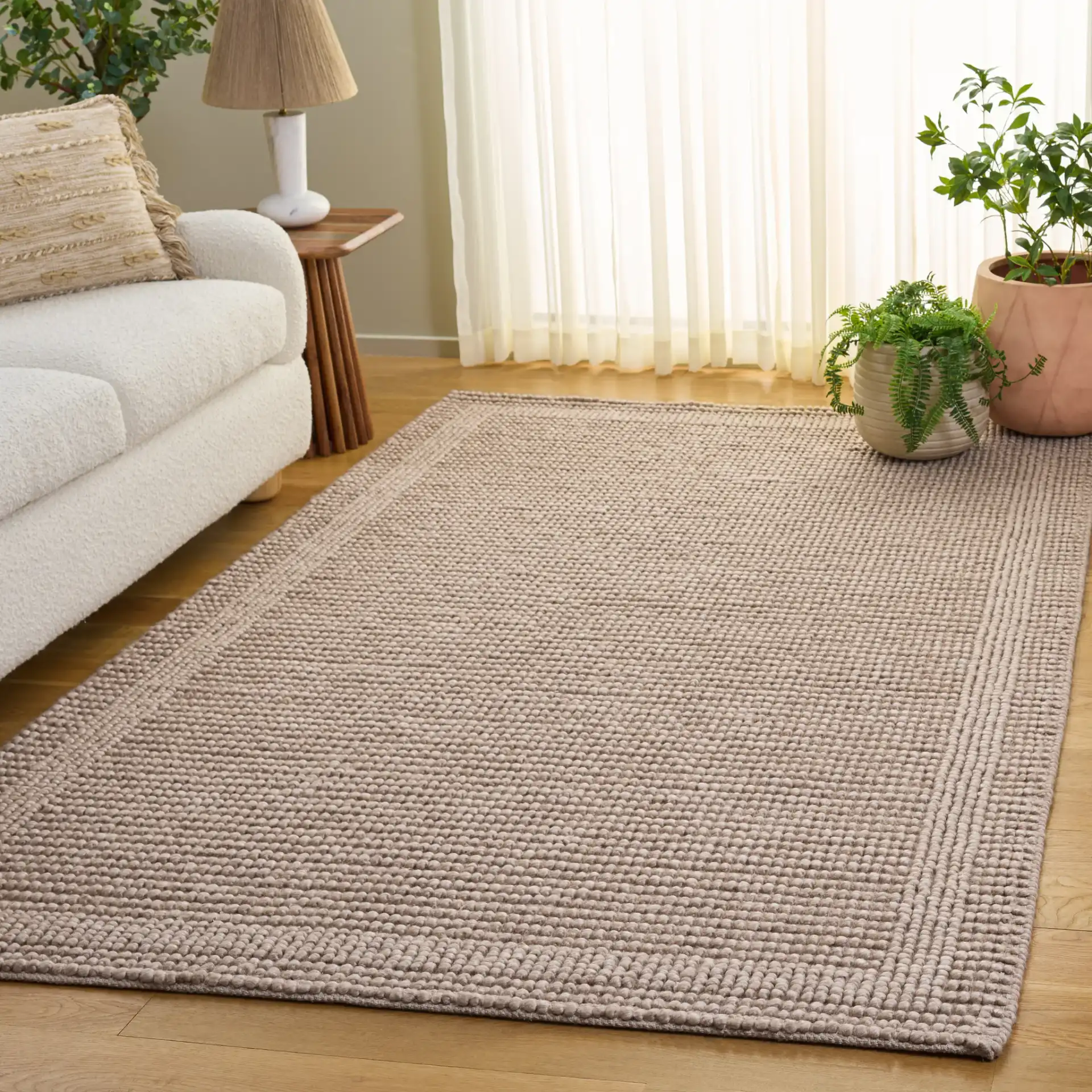 Natura Textured Bordered Hand-Woven Rug in Beige in a styled room