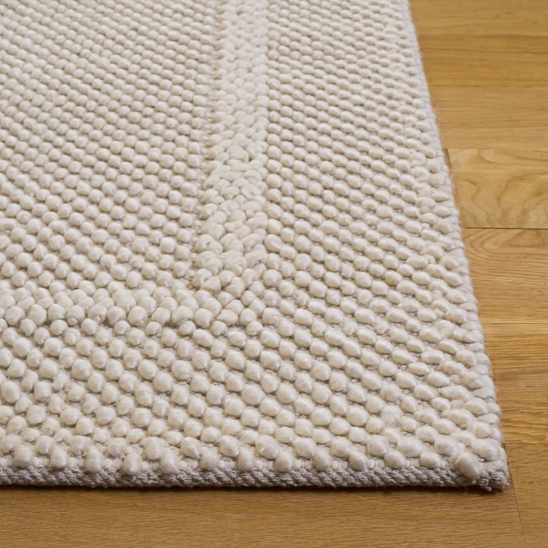 Natura Pebble Border Hand-Woven Rug in Ivory in a styled room
