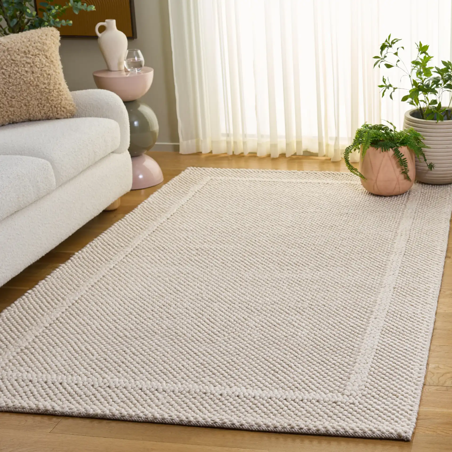 Natura Pebble Border Hand-Woven Rug in Ivory in a styled room