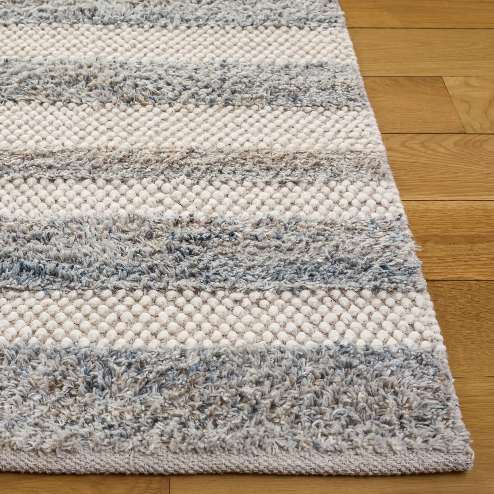 Natura Staggered Stripe Hand-Loomed Wool Blend Rug in Blue / Ivory in a styled room