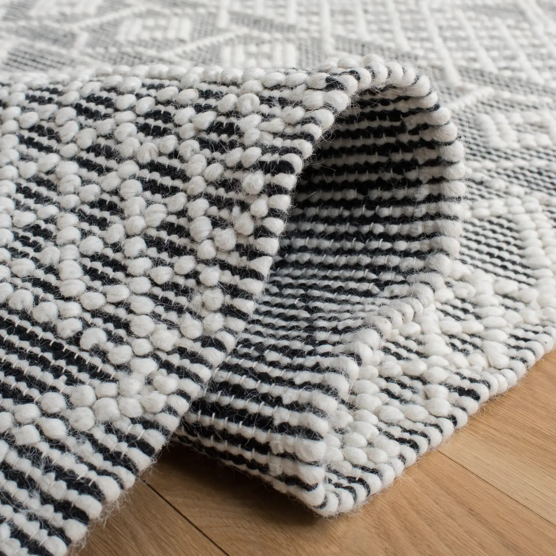 Natura Tribal Chevron Stripe Hand-Loomed Wool Rug in Ivory / Black in a styled room